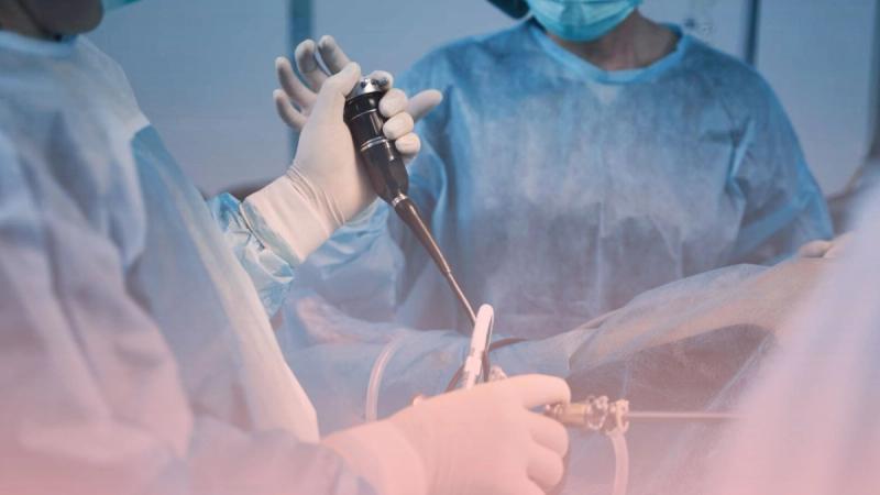 Detalle de las manos enguantadas de un equipo médico en el quirófano manipulando instrumental avanzado de cirugía laparoscópica. Esta tecnología mínimamente invasiva es utilizada por nuestro cirujano general para procedimientos seguros como la operación de vesícula.