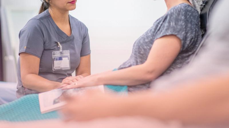 Profesional de la salud sosteniendo cálidamente las manos de una paciente, reflejando la contención humana en nuestro servicio integral de oncología.
