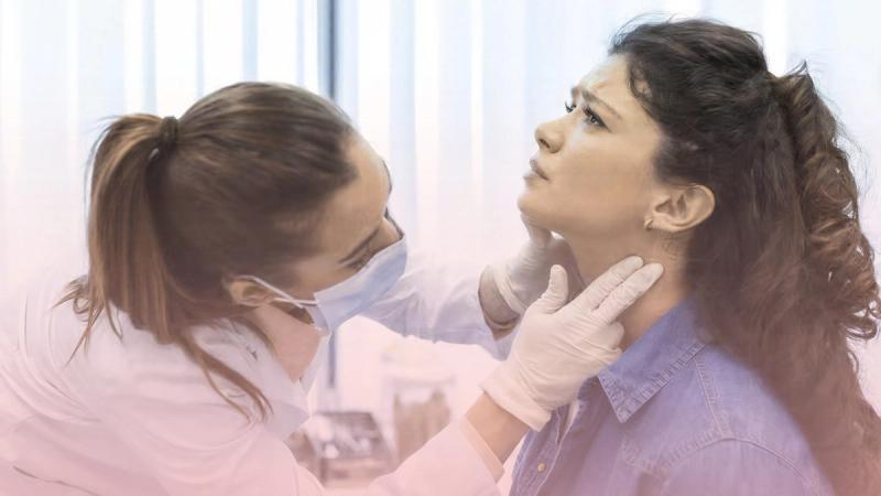 Médica endocrinóloga palpando cuidadosamente el cuello de una paciente para el control preventivo de la tiroides y detección de nódulos.