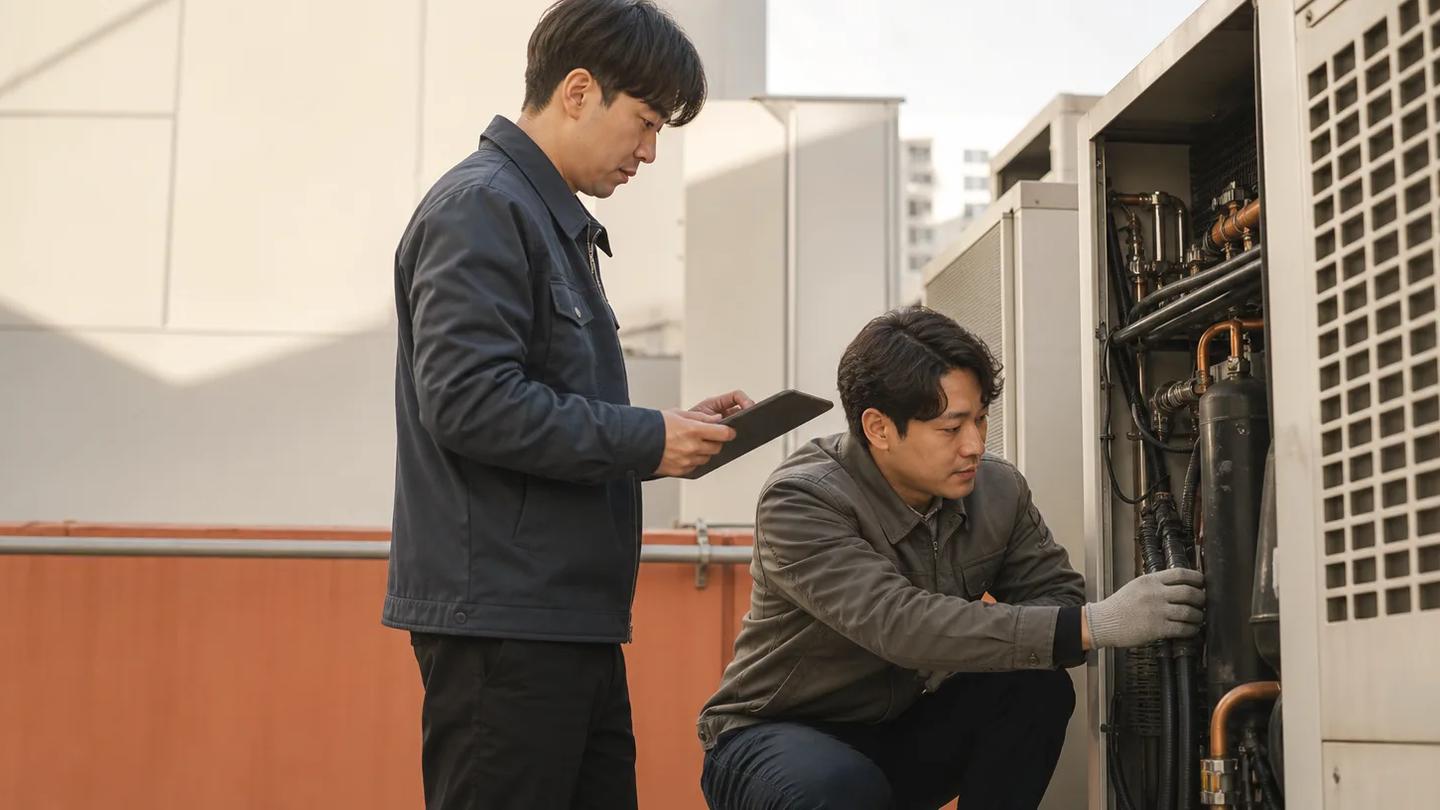 설비가 있는 고객 현장에서 태블릿으로 방문 내용을 확인하는 두 명의 현장 담당자