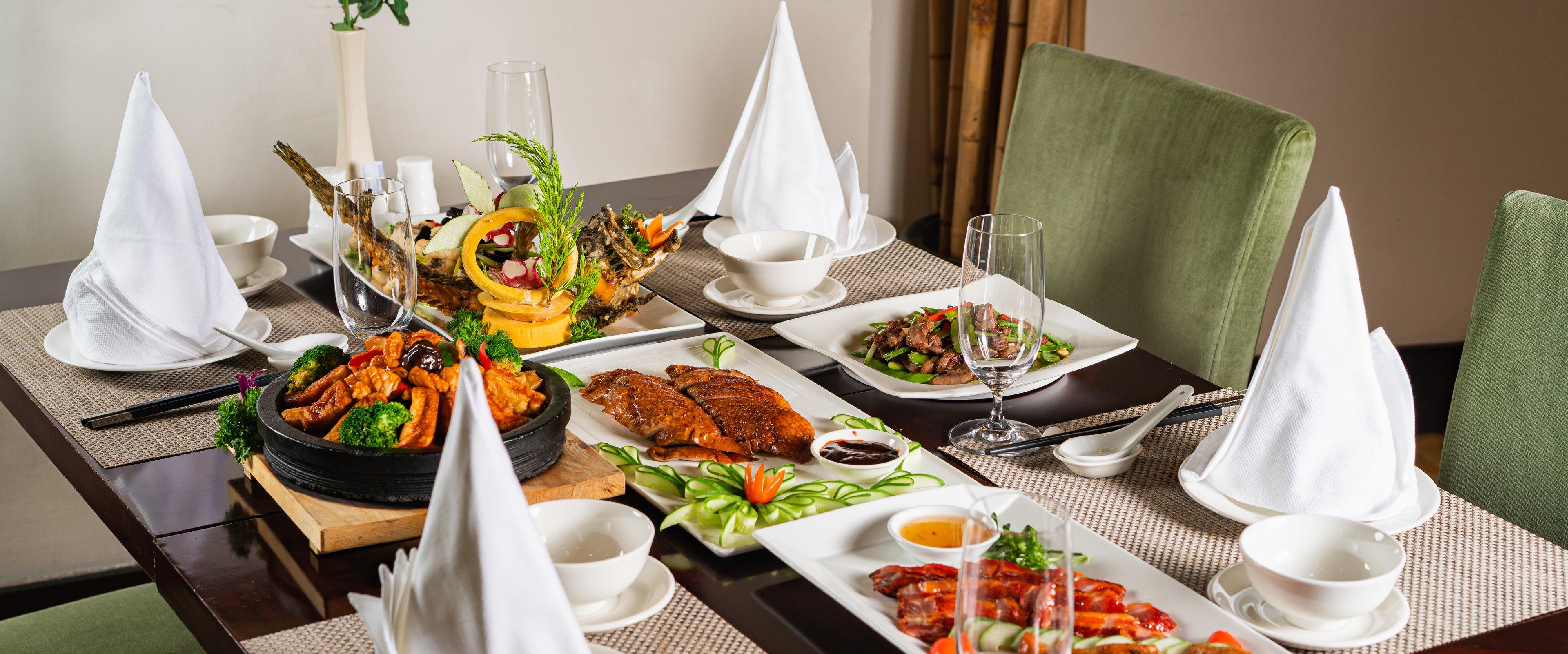 Bàn ăn bày sẵn nhìn ra cửa kính lớn hướng vịnh