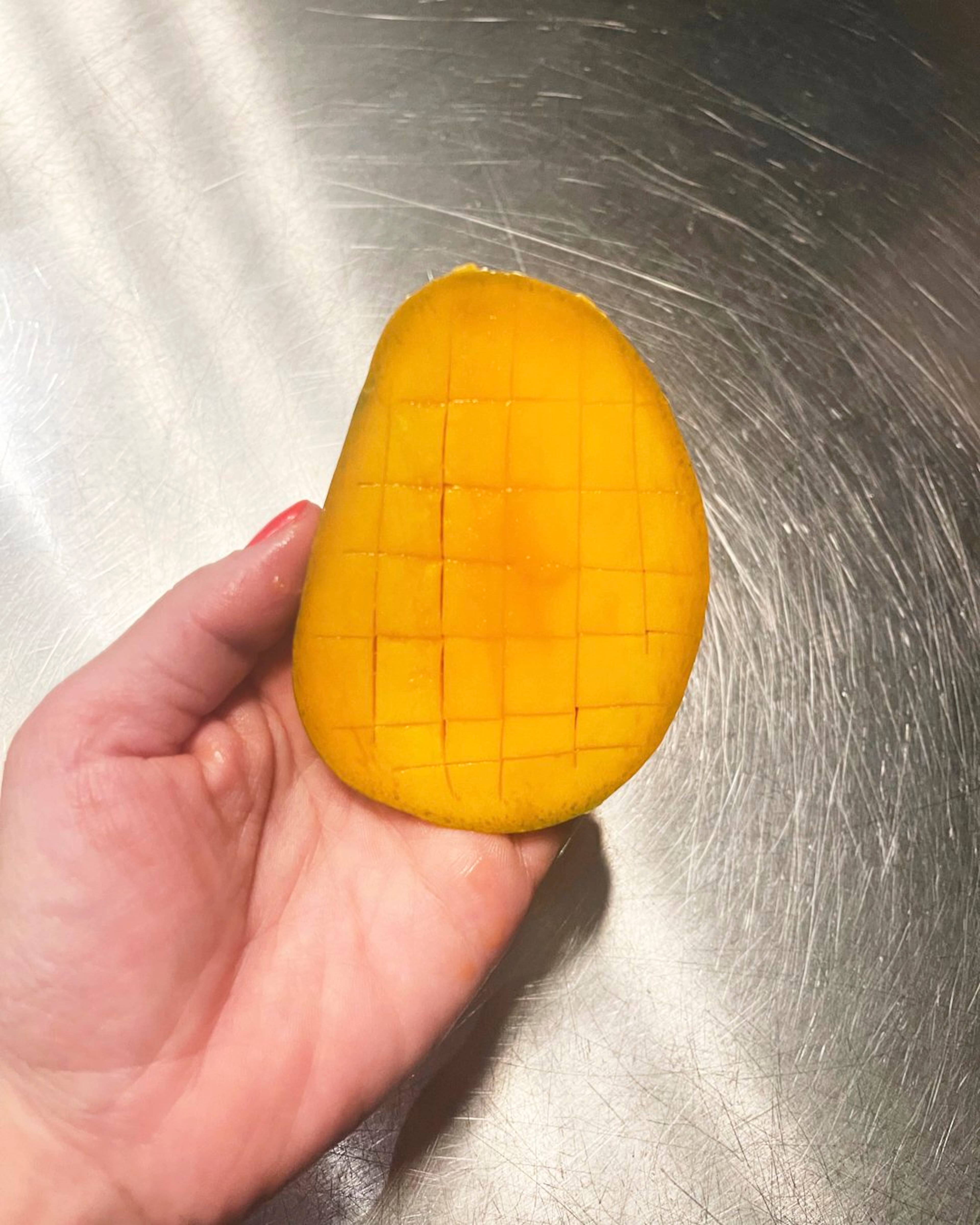 Mango cut in half and sliced hedgehog style