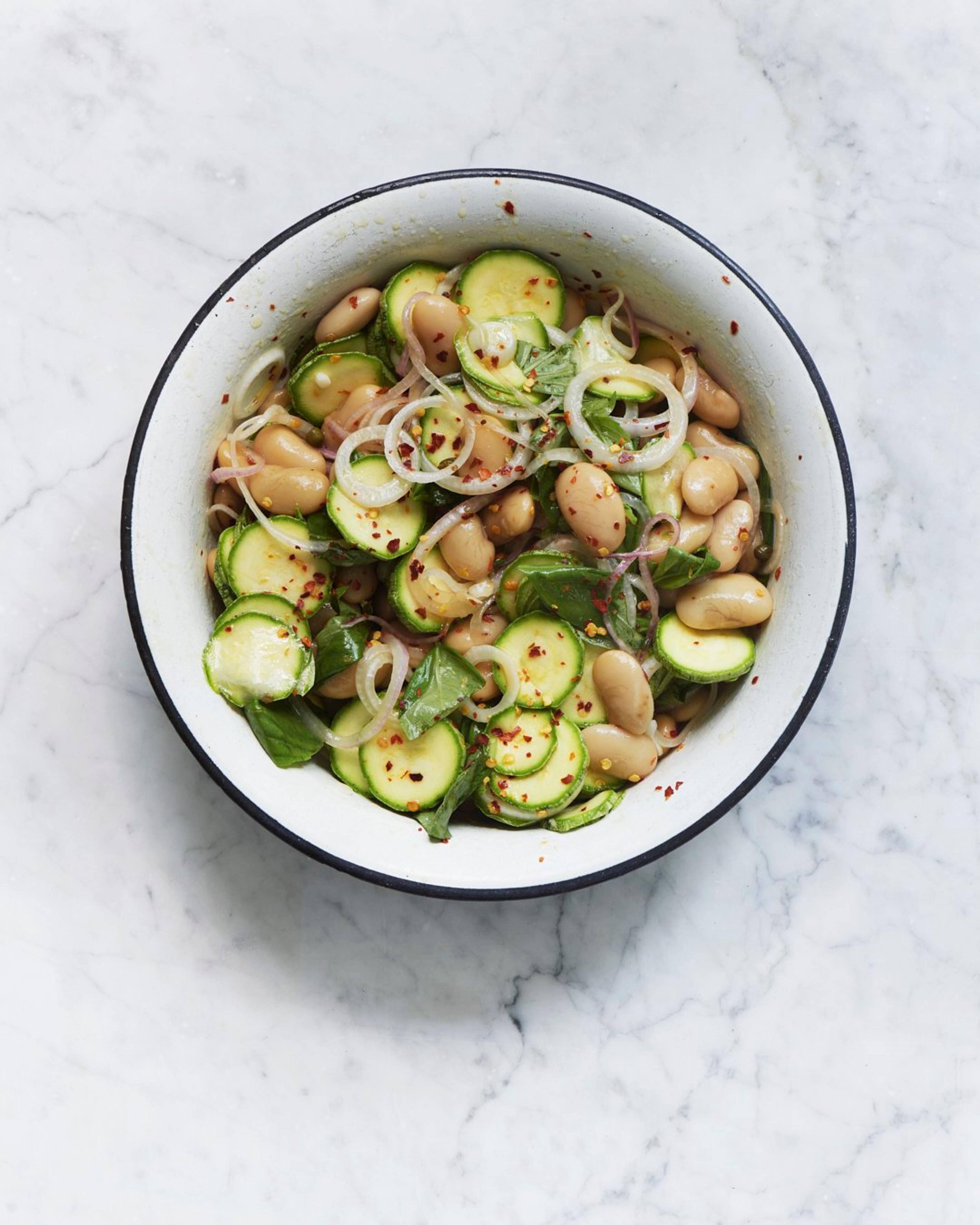 Courgette salad in serving dish and plates