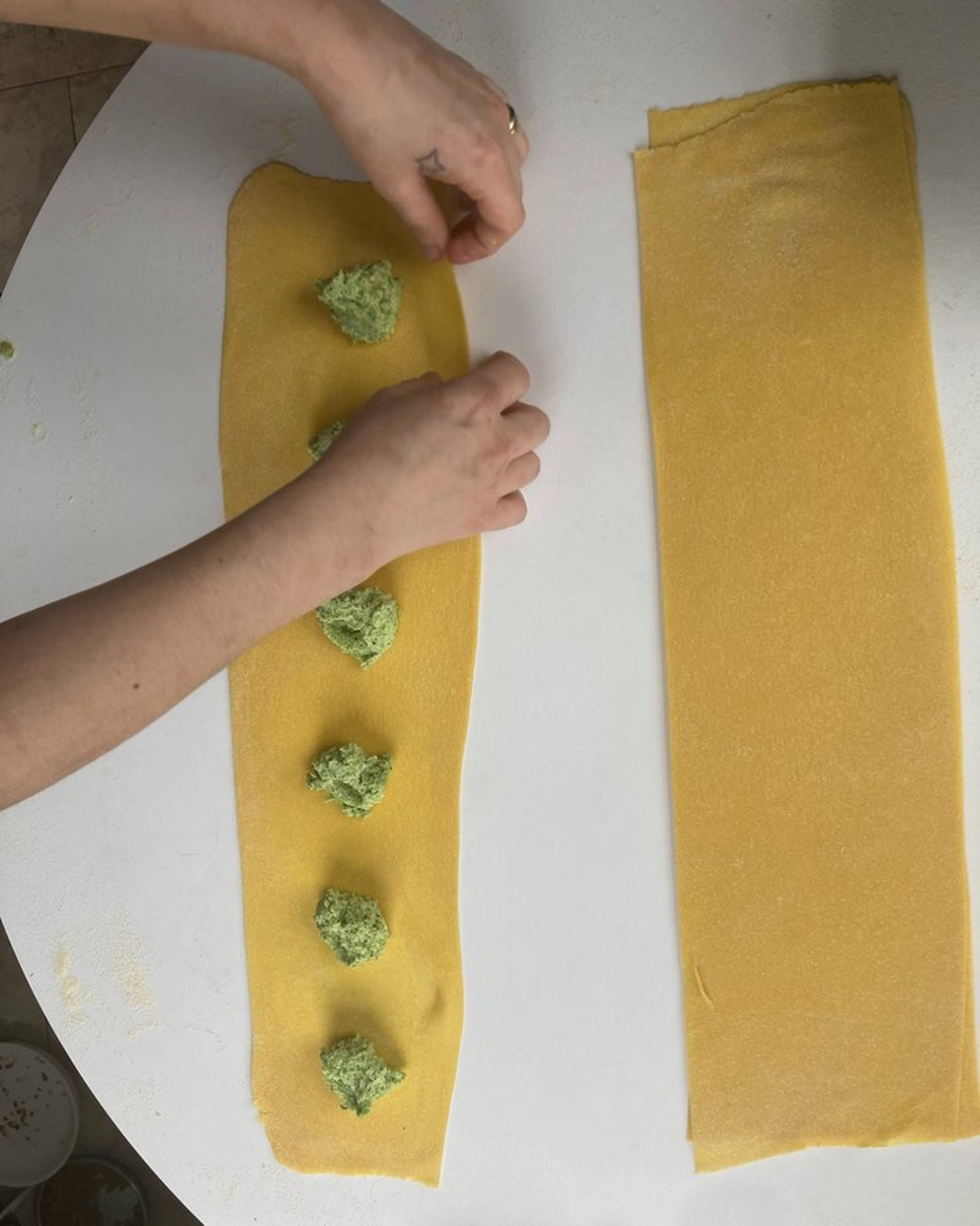 Tablespoons of filling along the pasta sheet