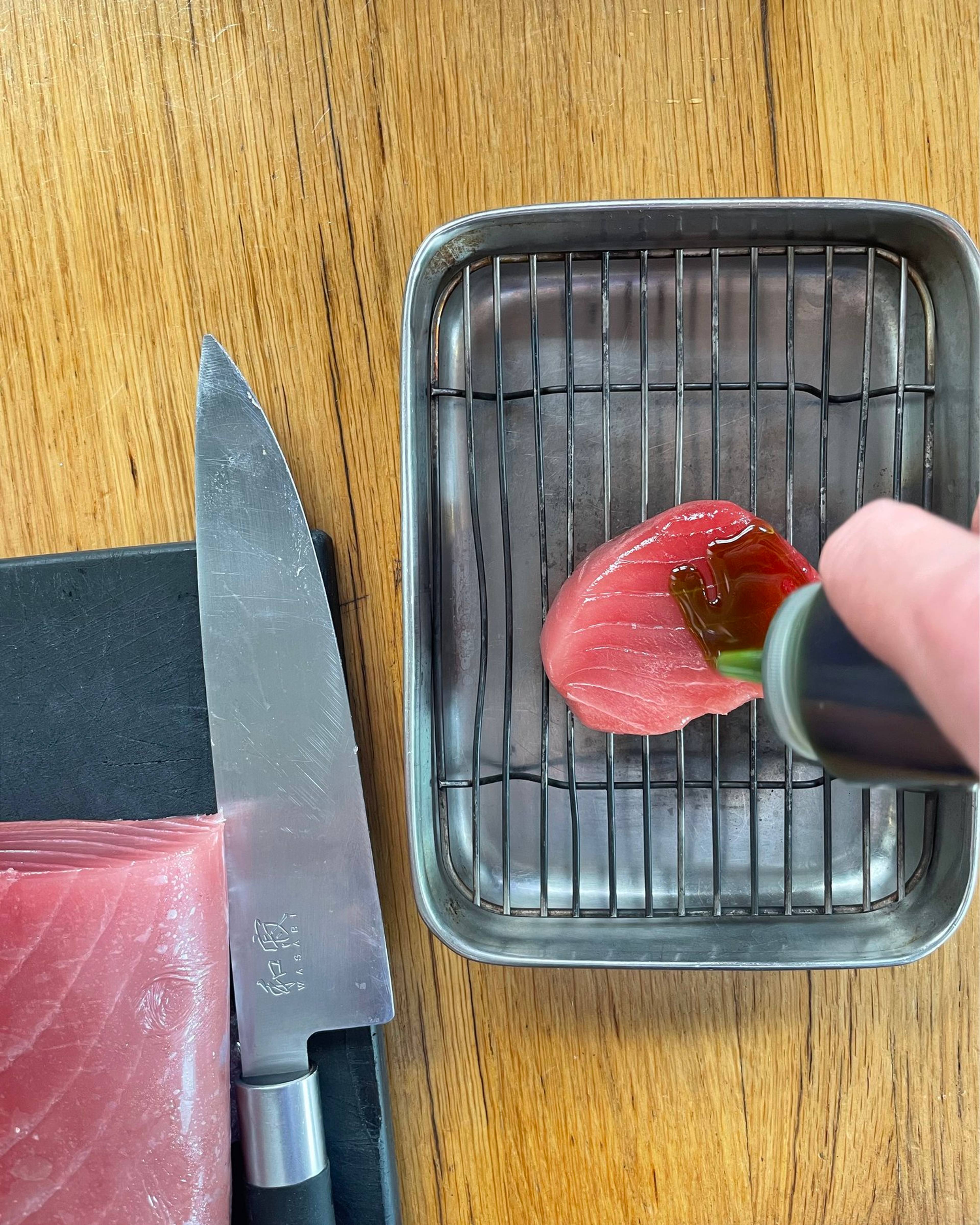 Dressing the tuna steak with fig leaf oil