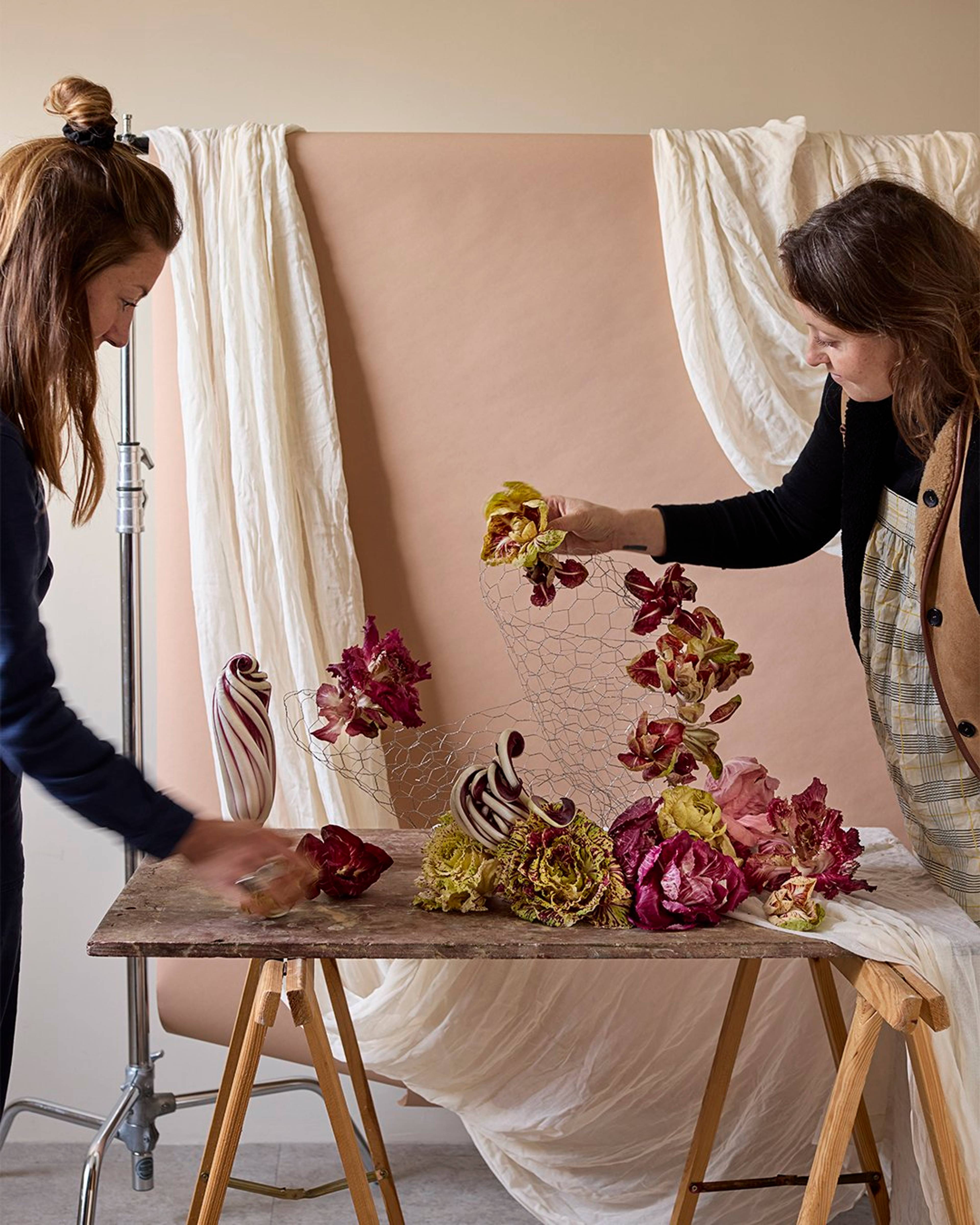 Two women from ssaw collective designing a table display with radicchio
