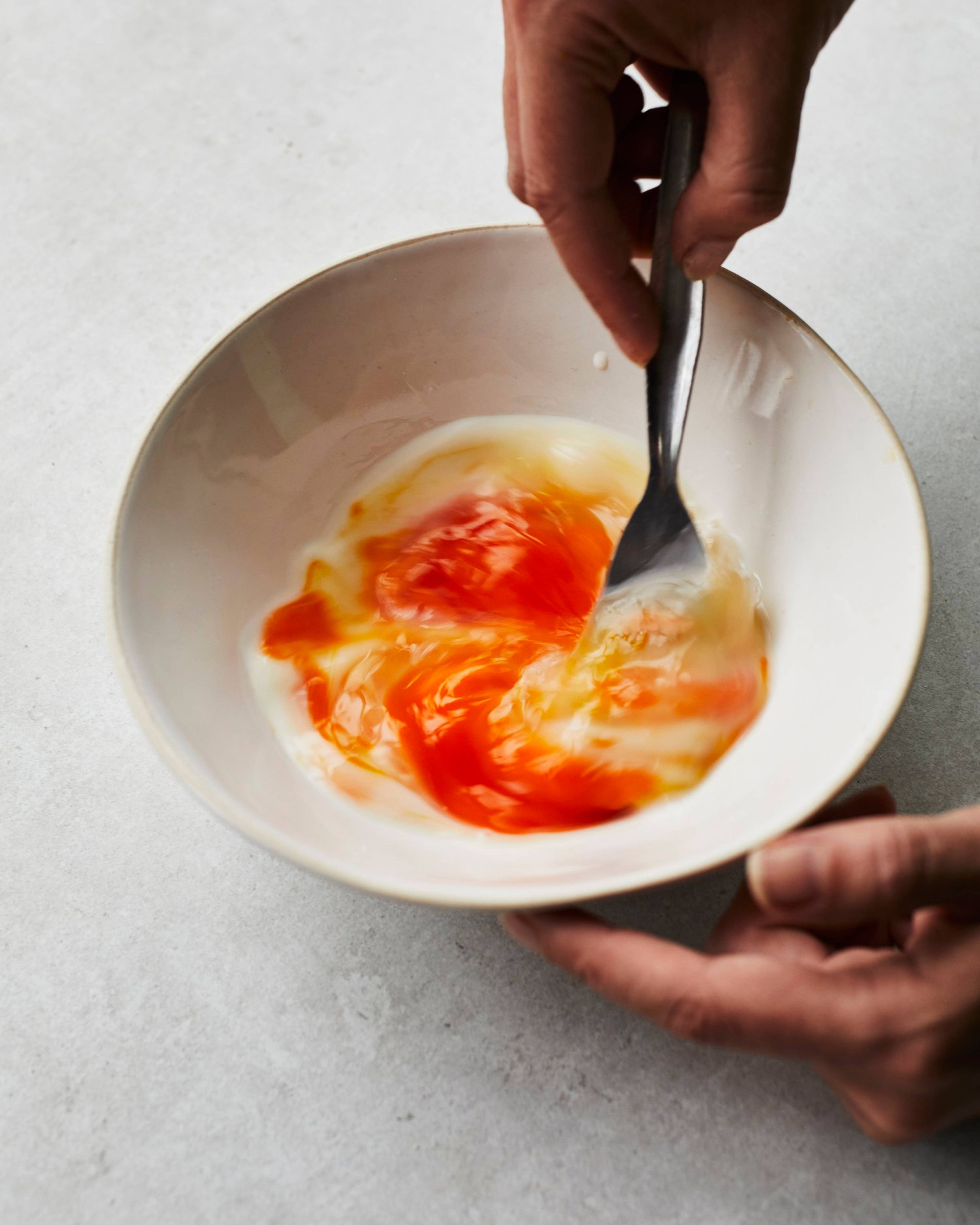 eggs being mixed in a bowl with a fork