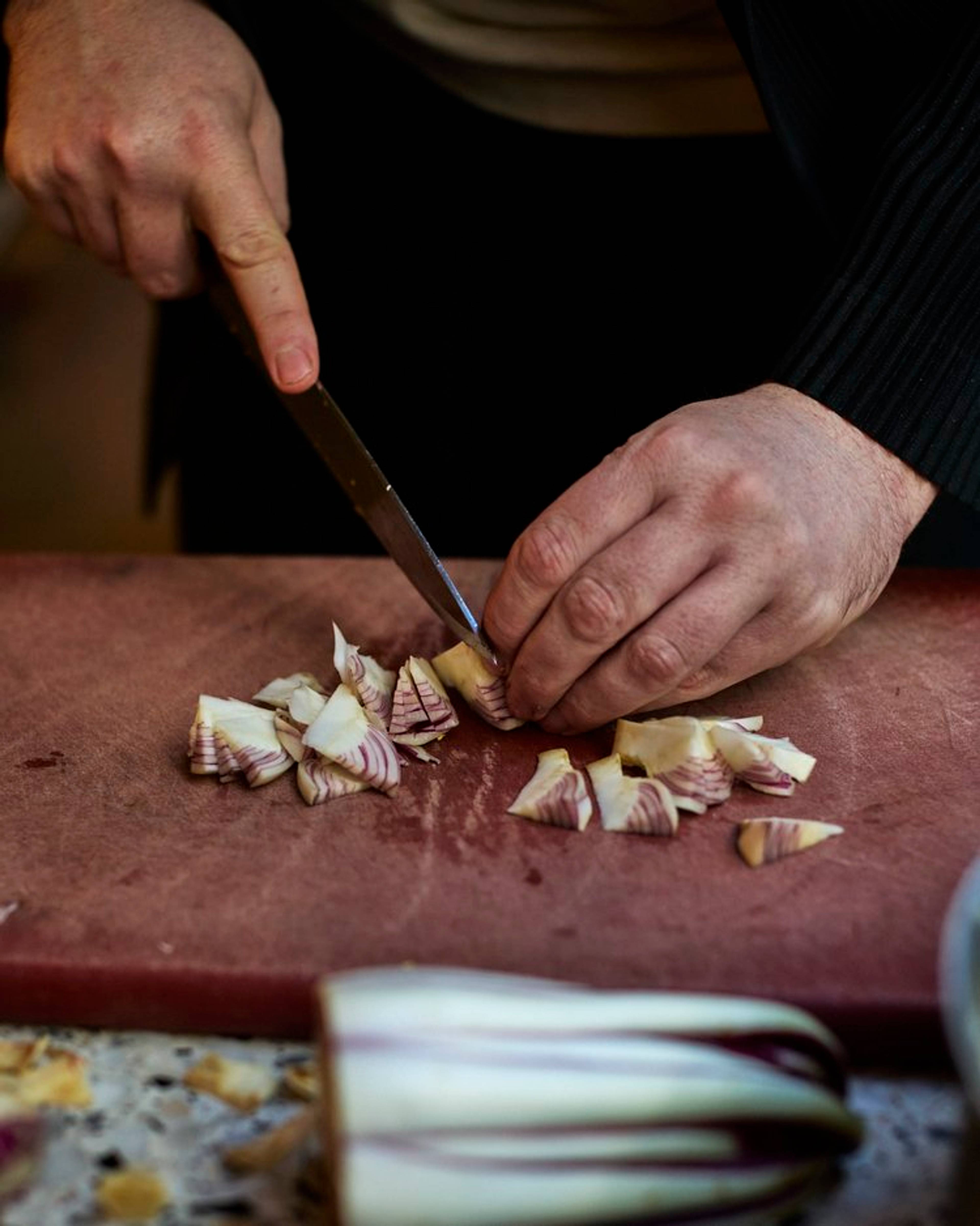 tardivo radicchio being sliced on a board