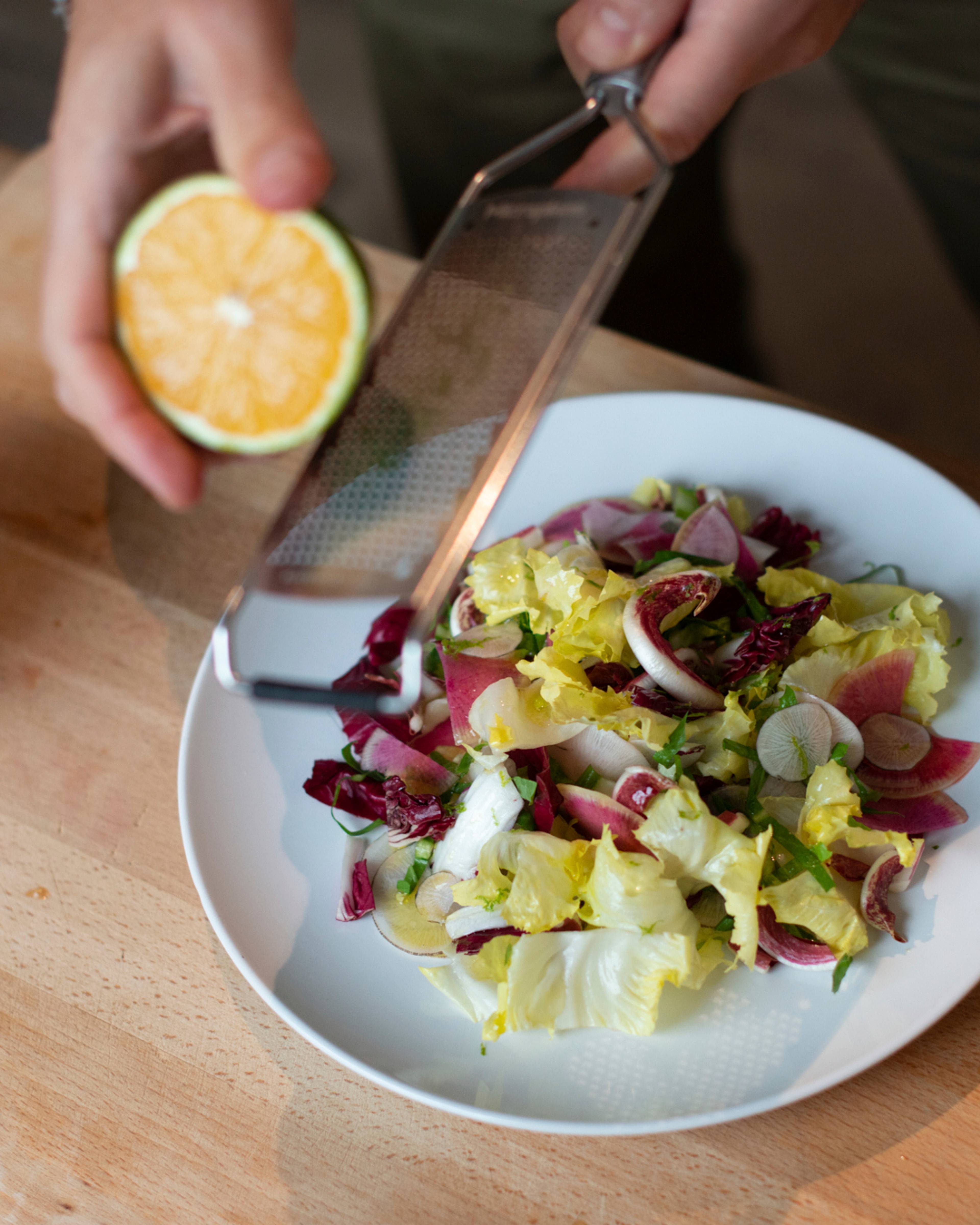 grating citrus zest onto the salad