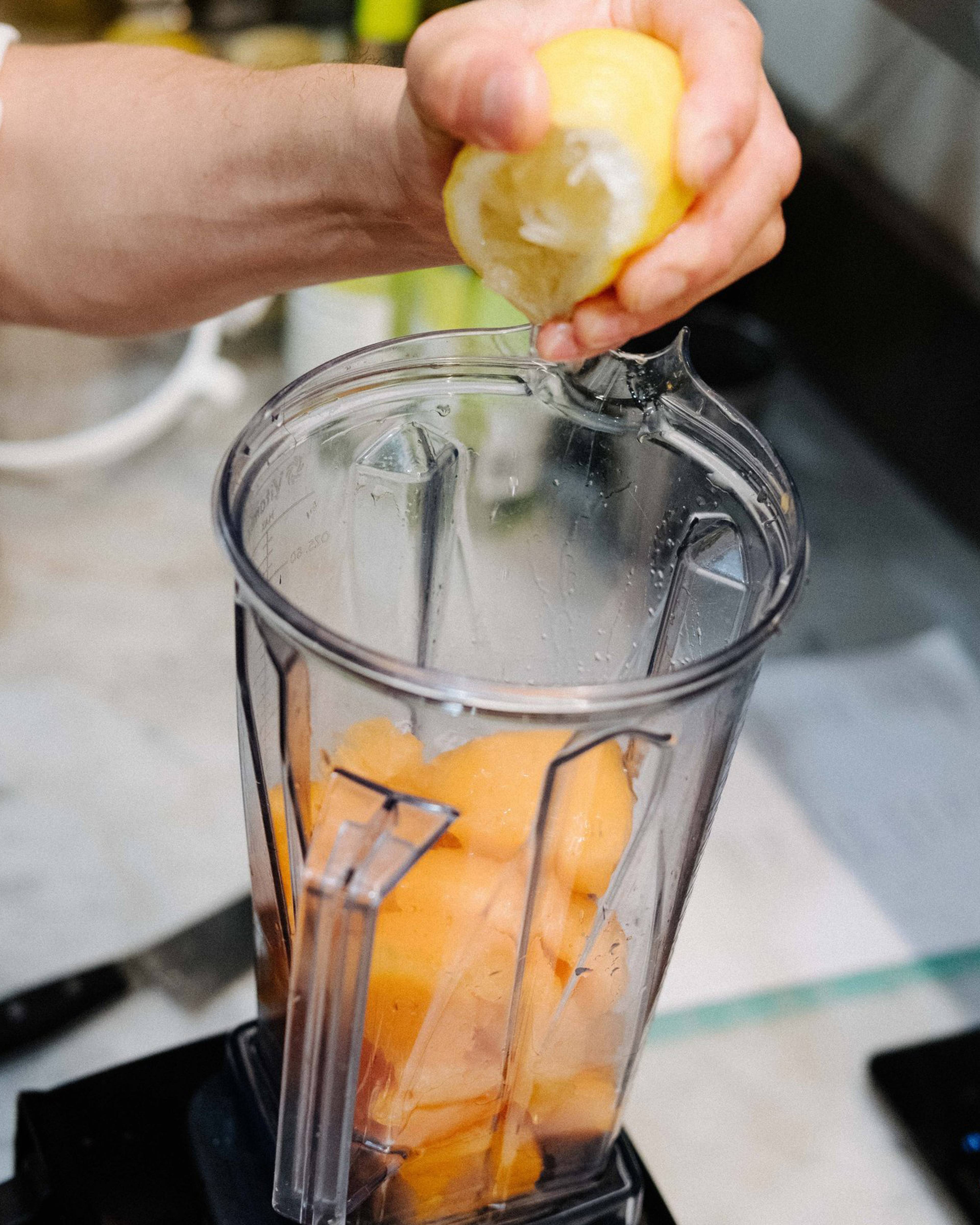 Squeezing lemon into the blender with other ingredients