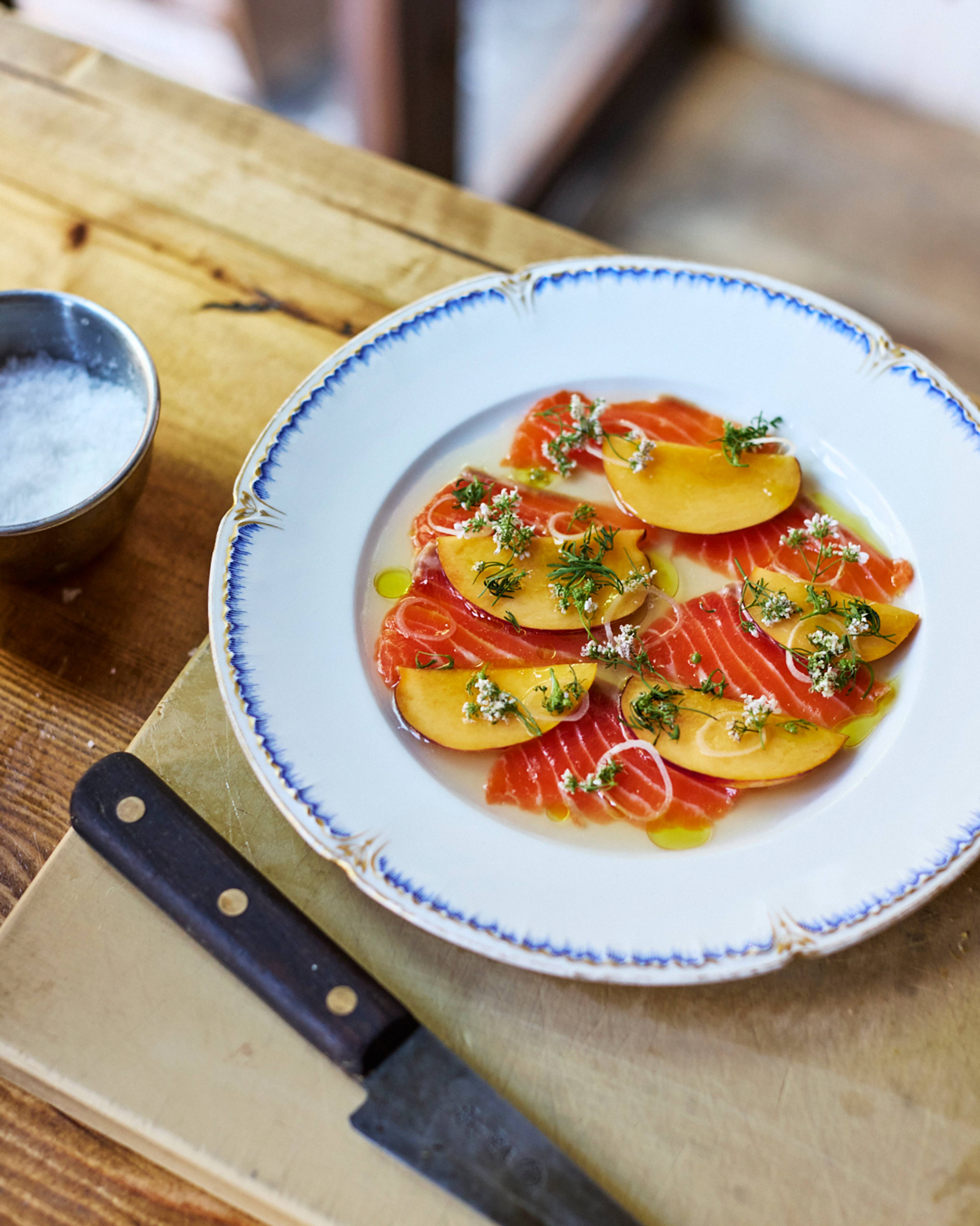 trout and nectarine crudo served on a white plate