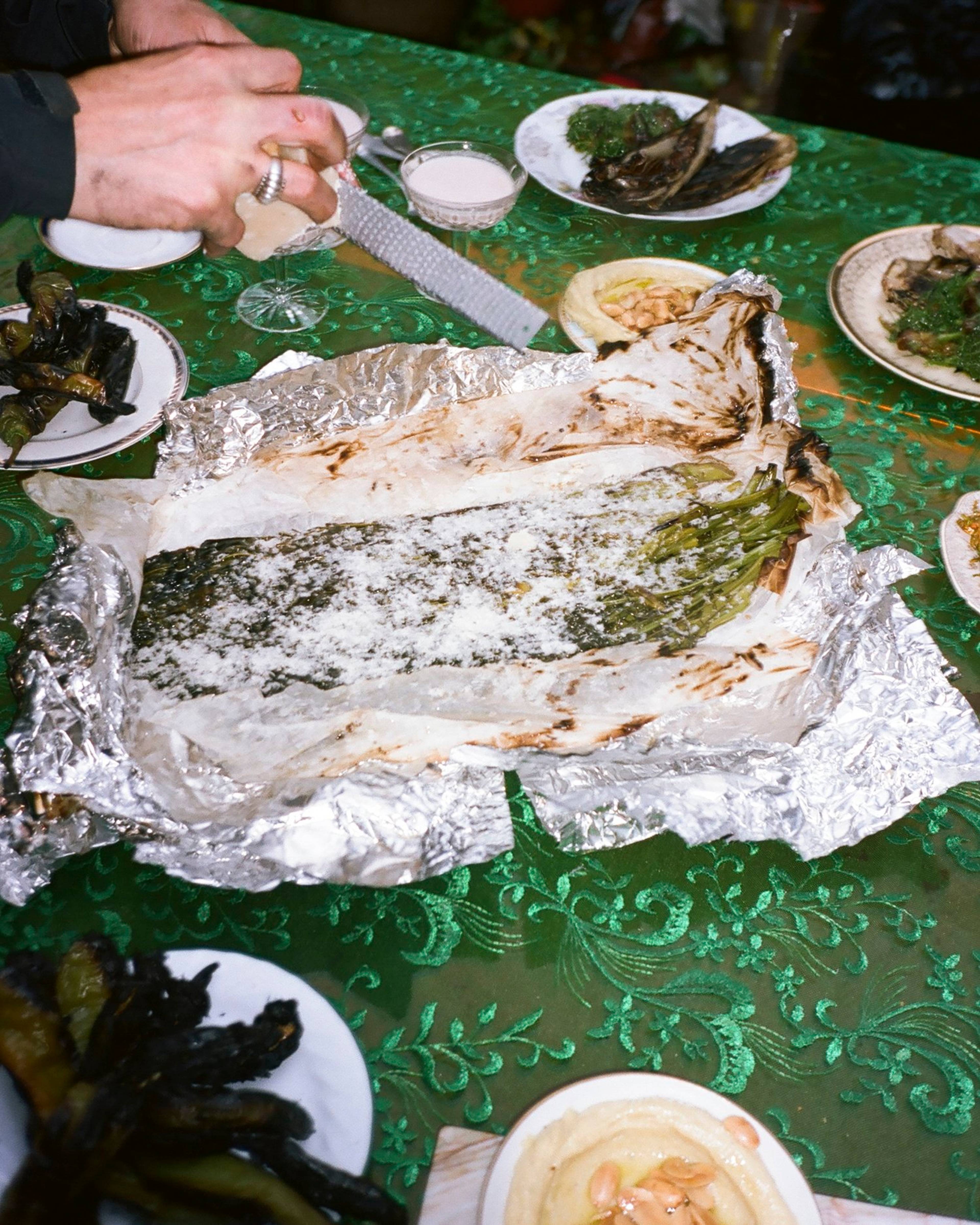 spigarello with anchovy butter unwrapped in foil on the table