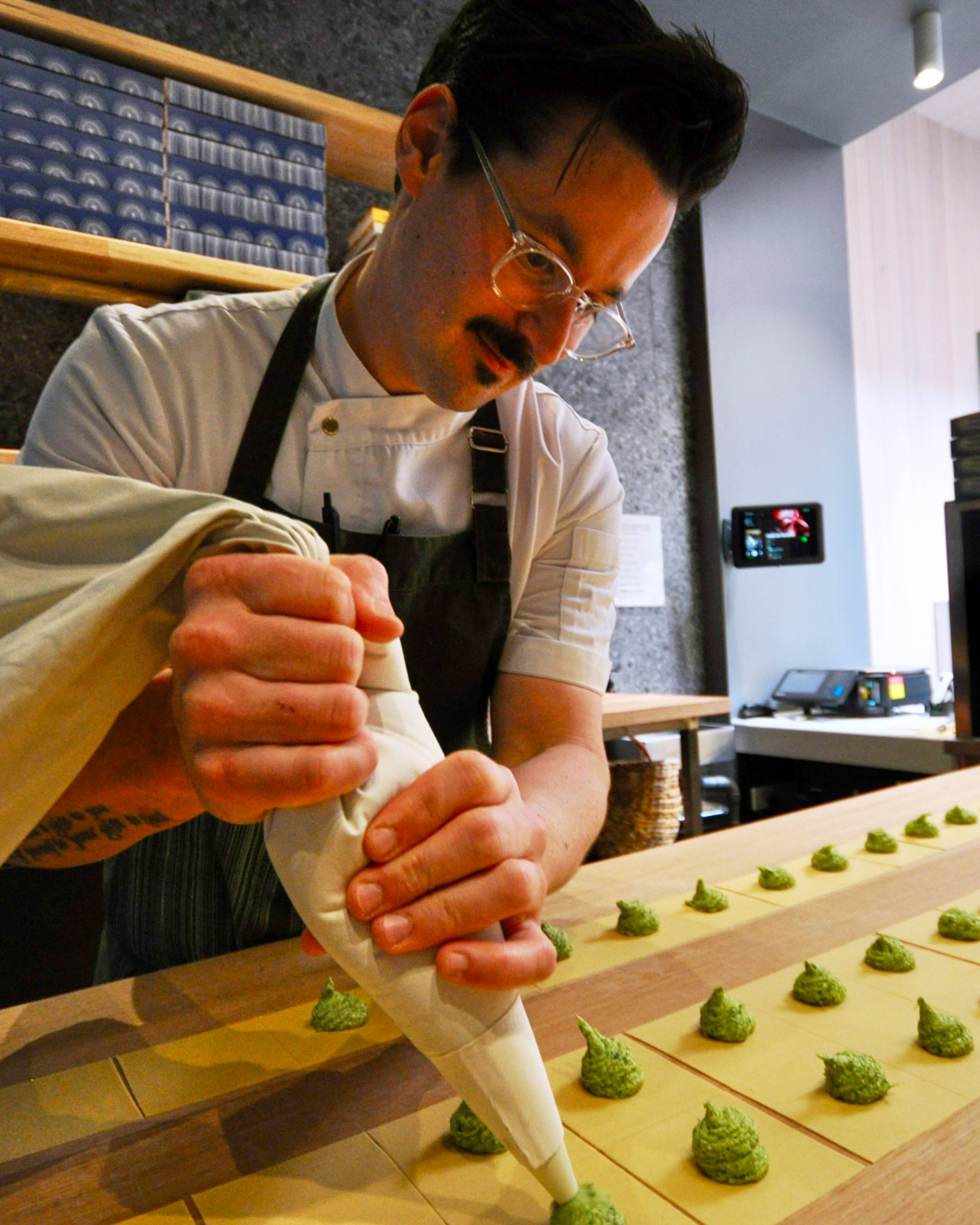 chef piping tortellini filling