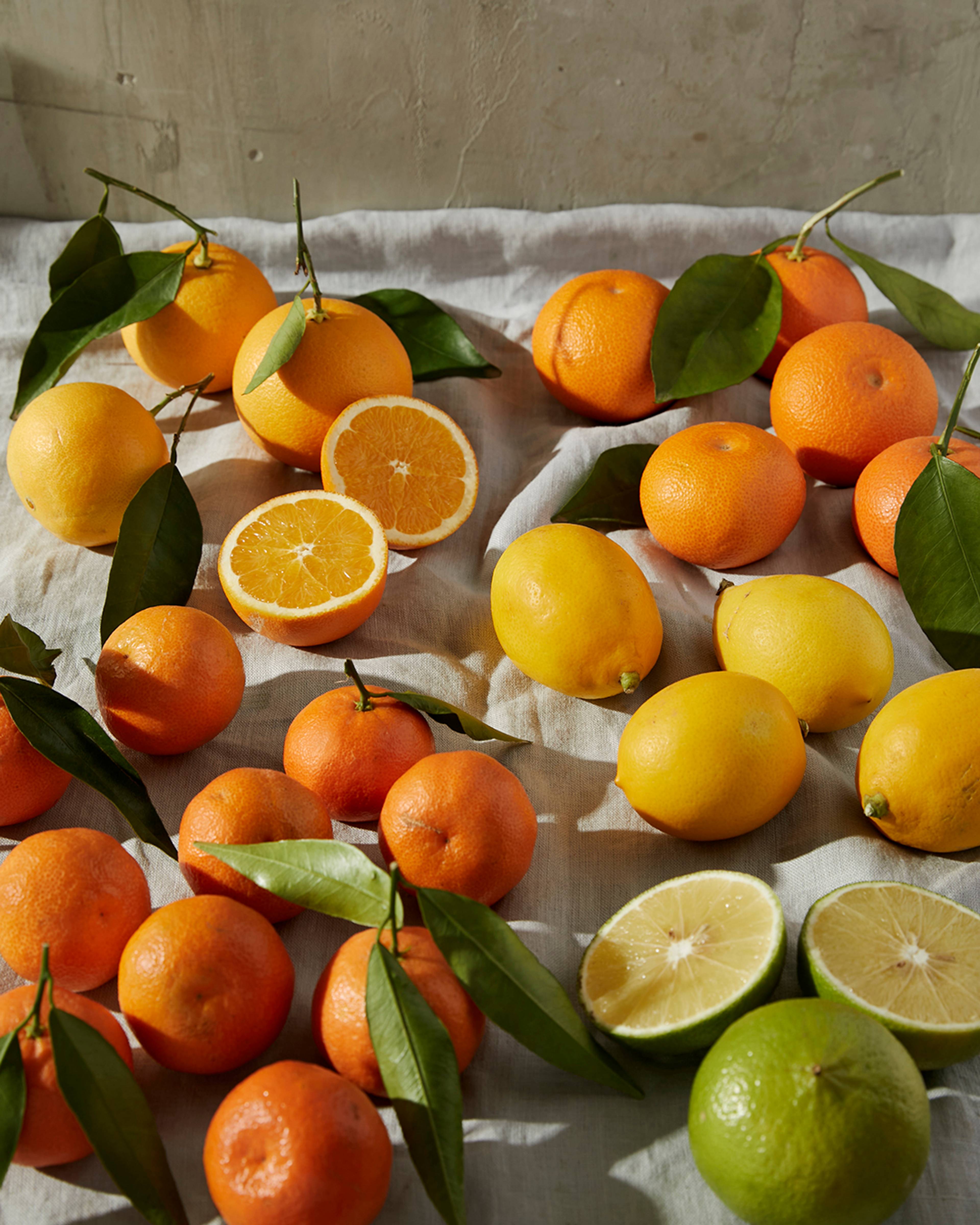 multiple leafy citrus varieties laid out on some linen