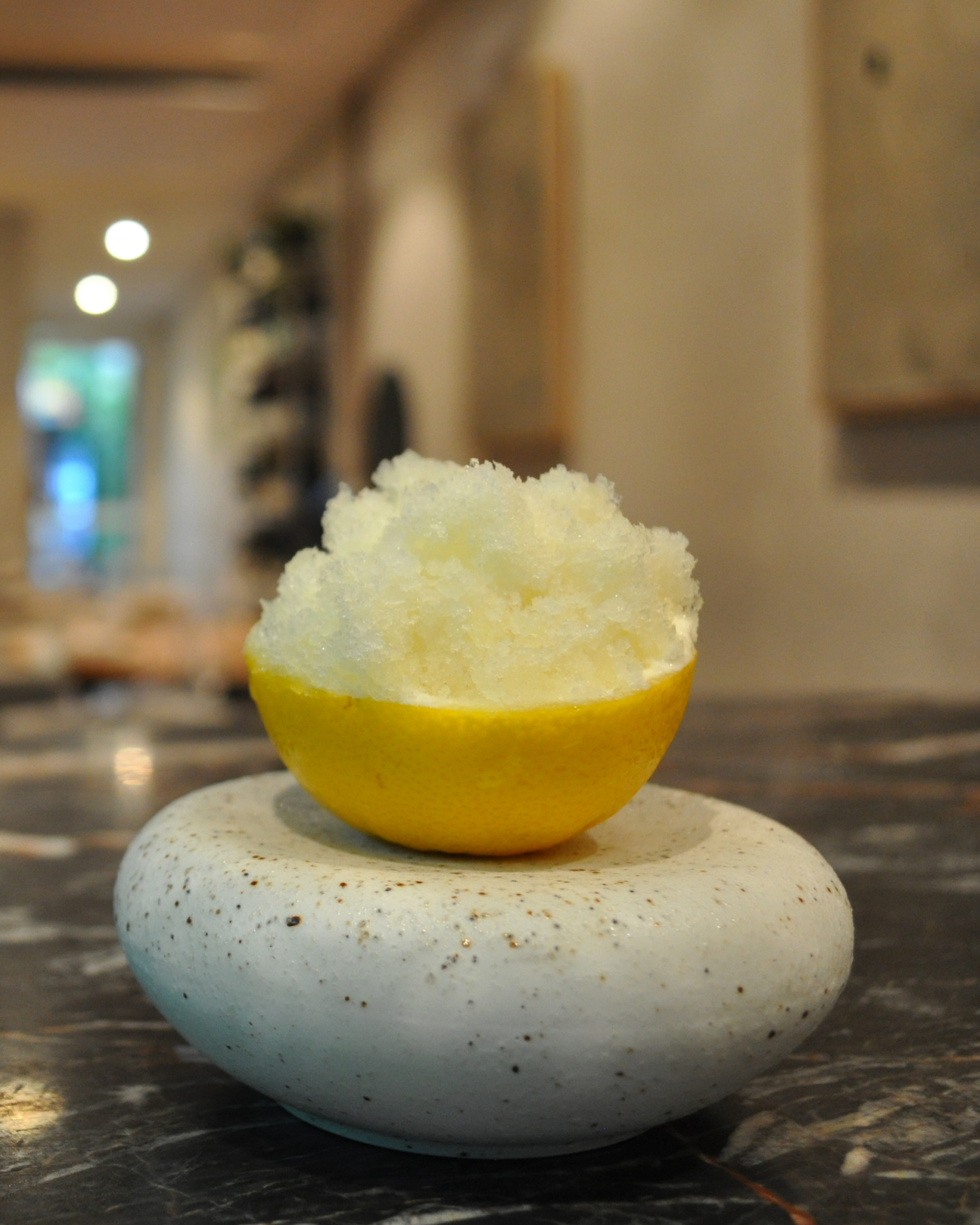 lemonade fruit granita served in the fruit skin on a stone
