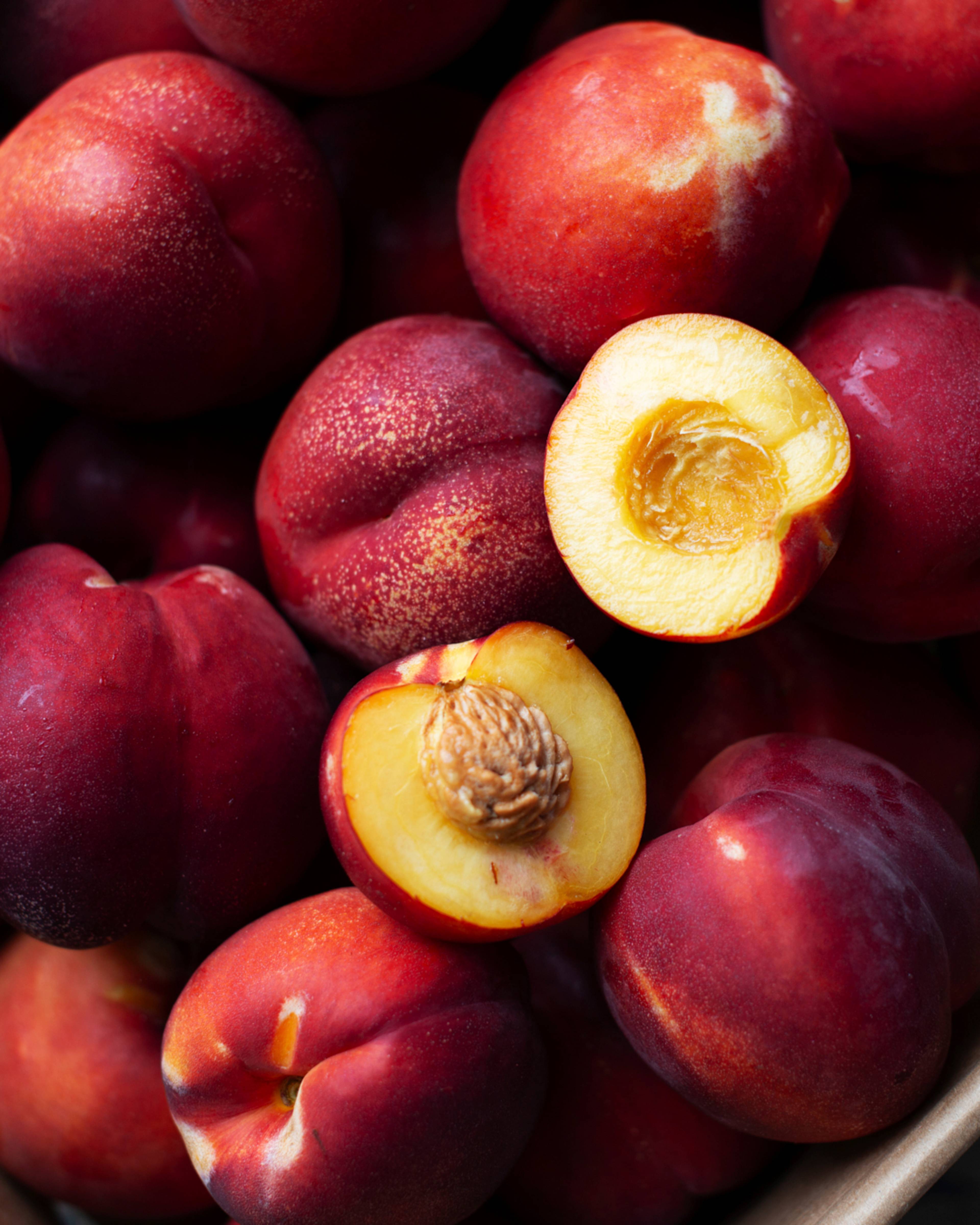 nectarine cut open on a pile of nectarines