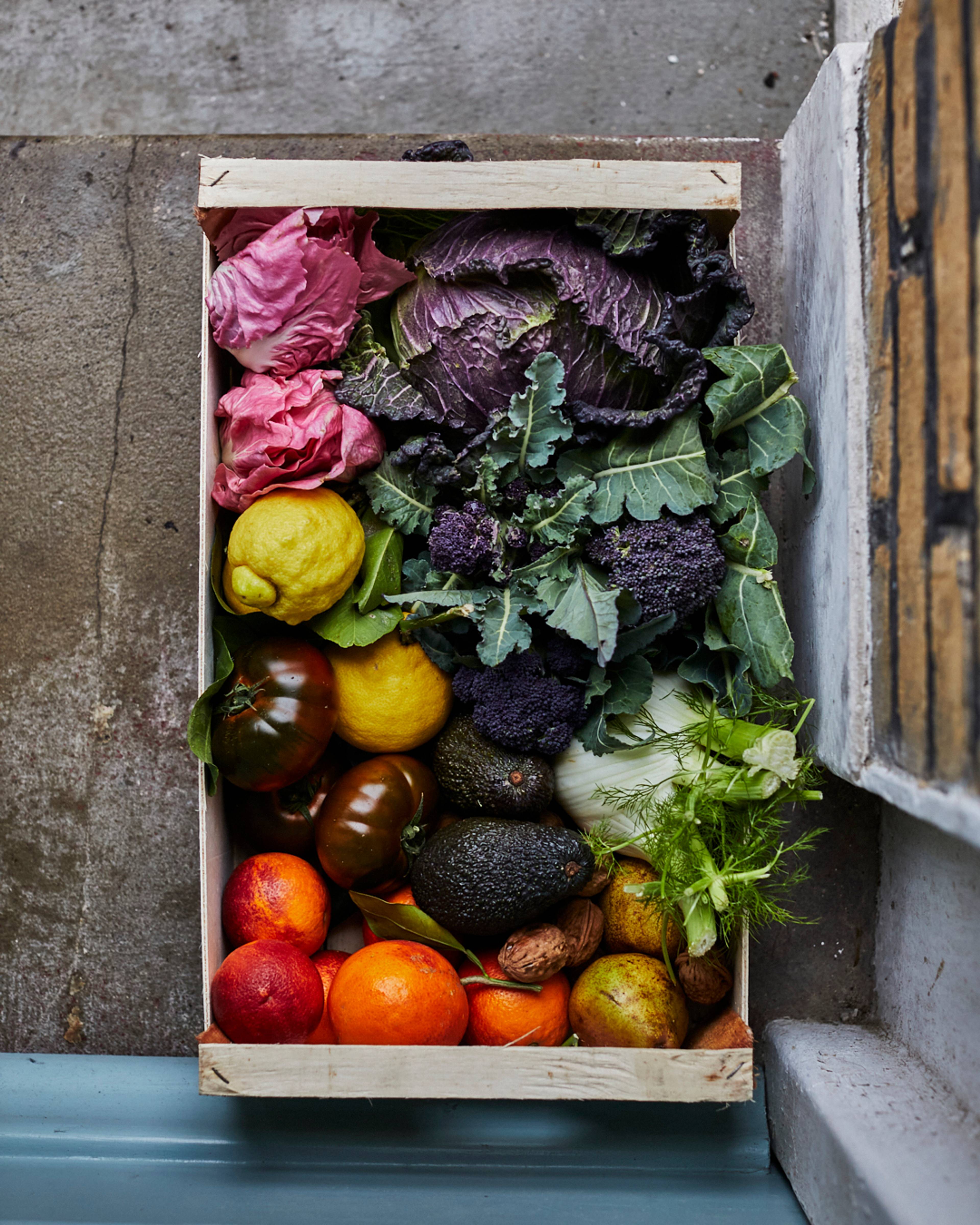 Overhead shot of a box of seasonal produce on a doorstep