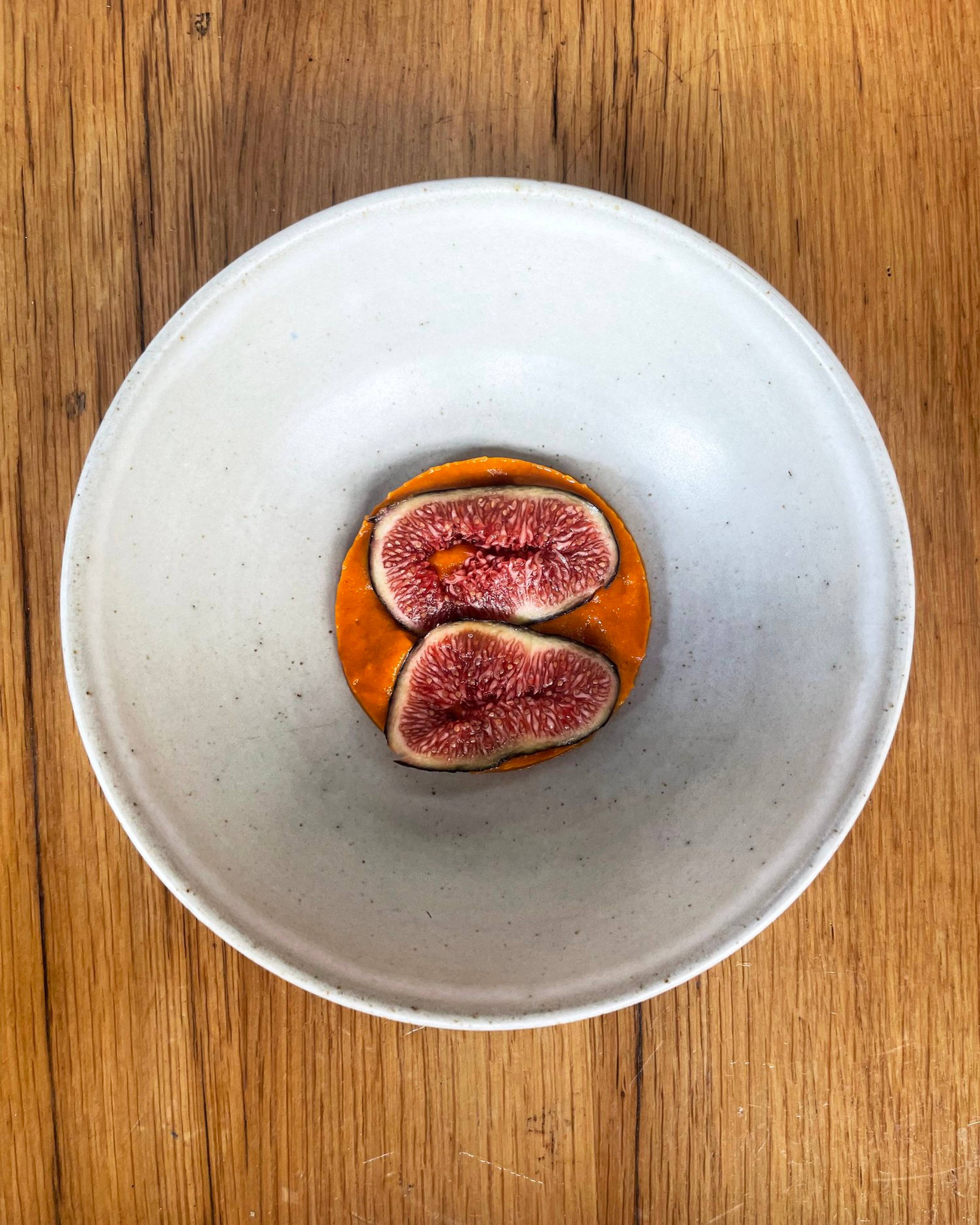 Black figs placed on top of the confit tomato sauce