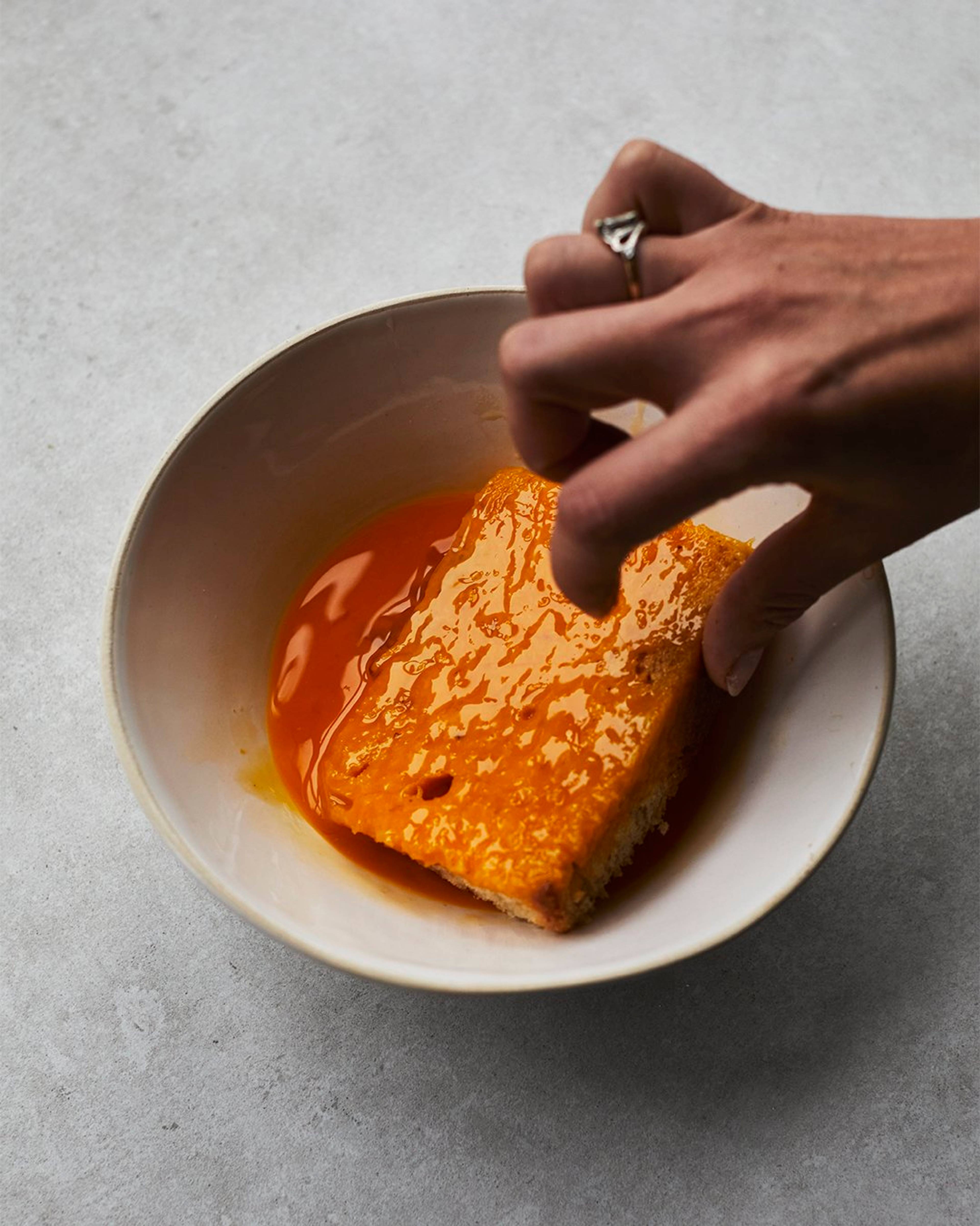 Bread being soaked in egg mix in a bowl