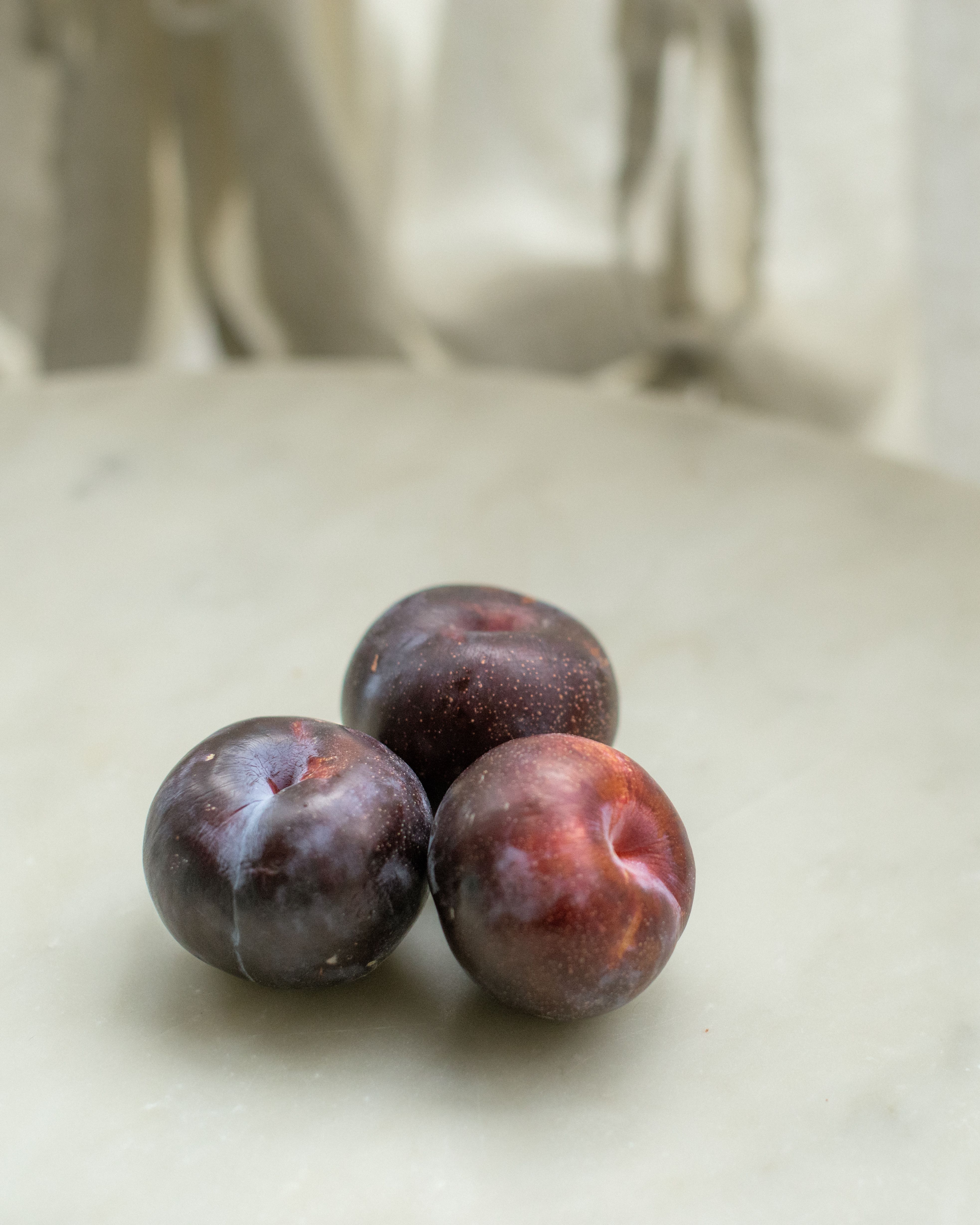 Three plums on a white background