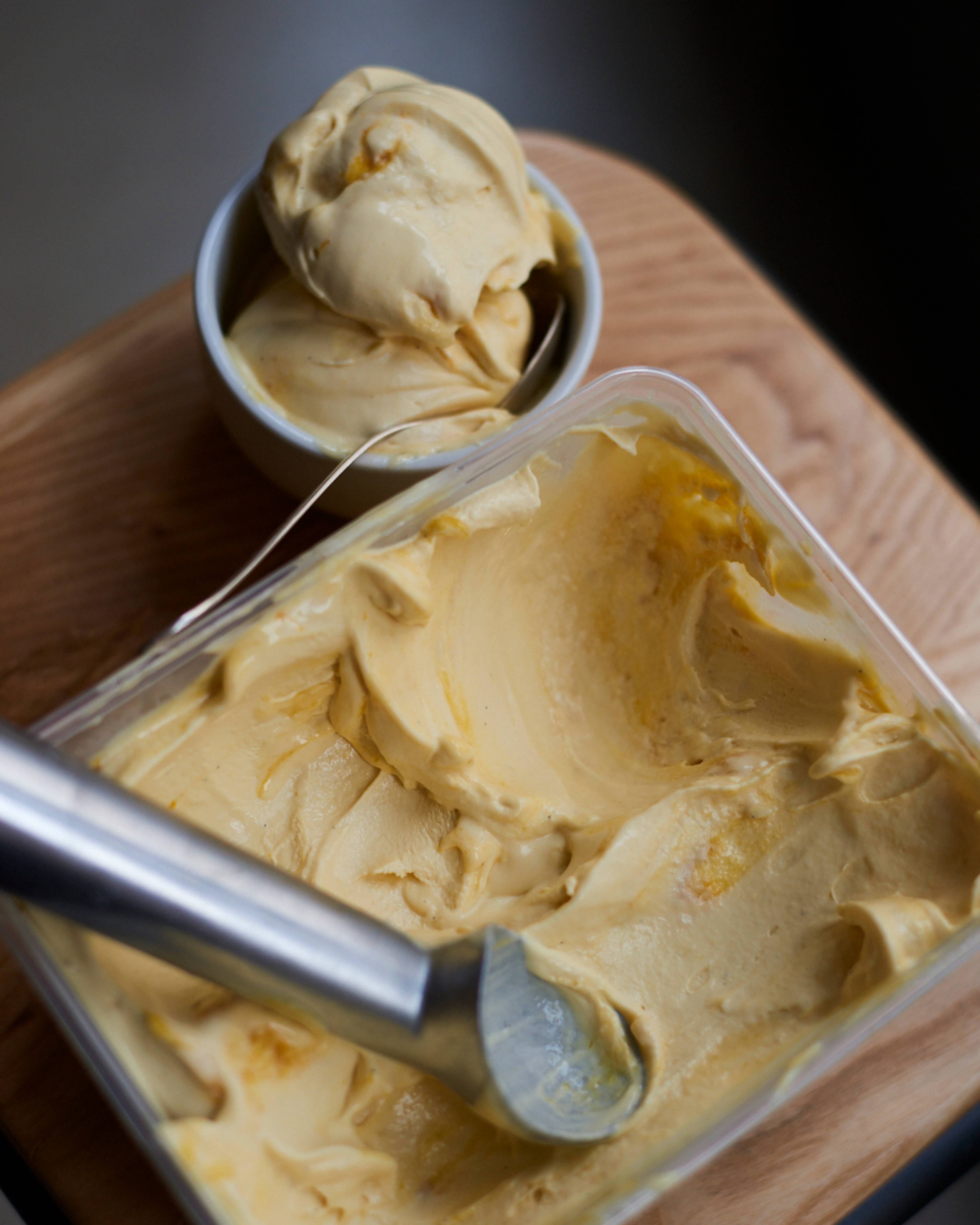 bowl of ice cream scoops next to tub of ice cream