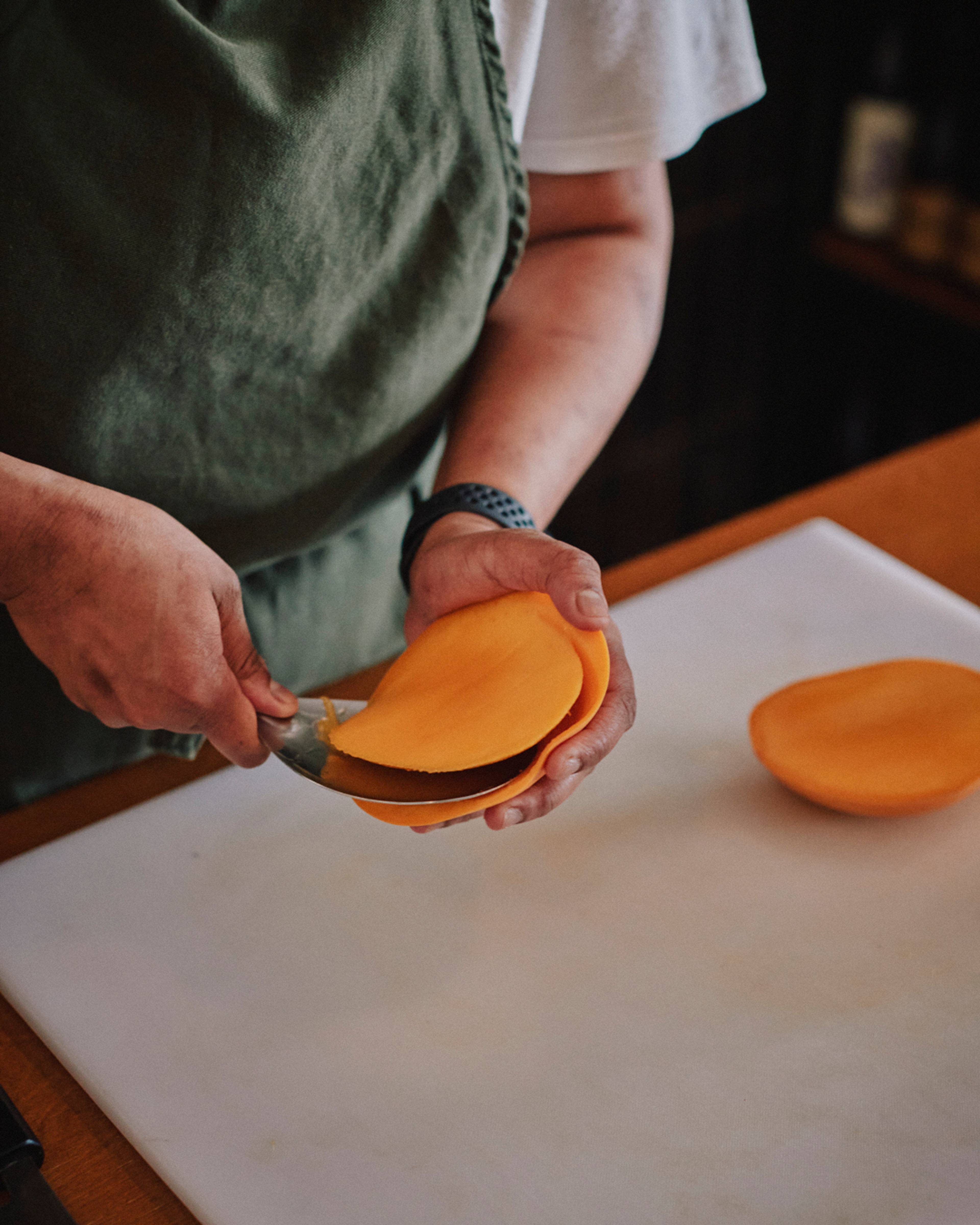 scooping out mango flesh