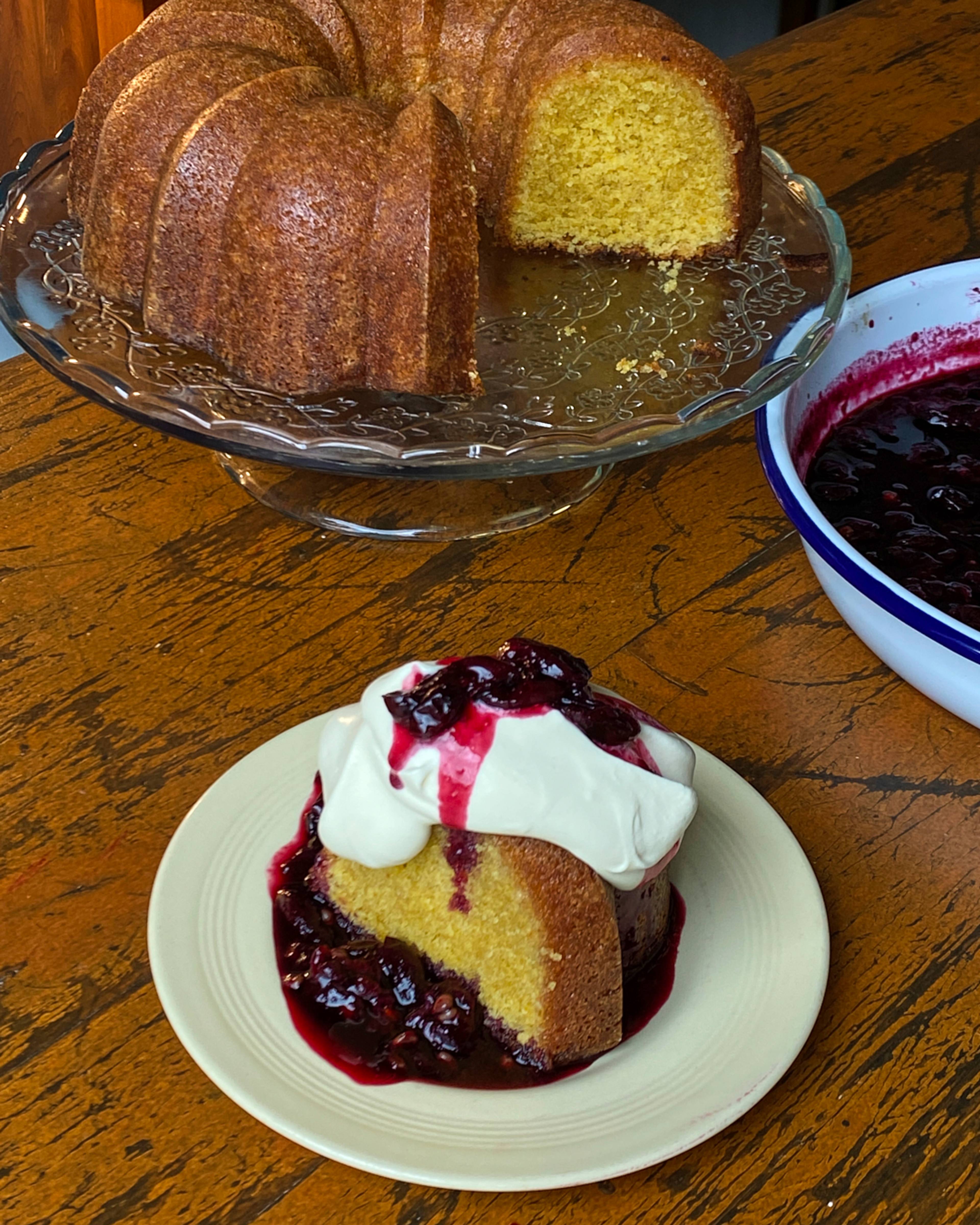 slice of cake with roasted fragola grapes and whipped cream