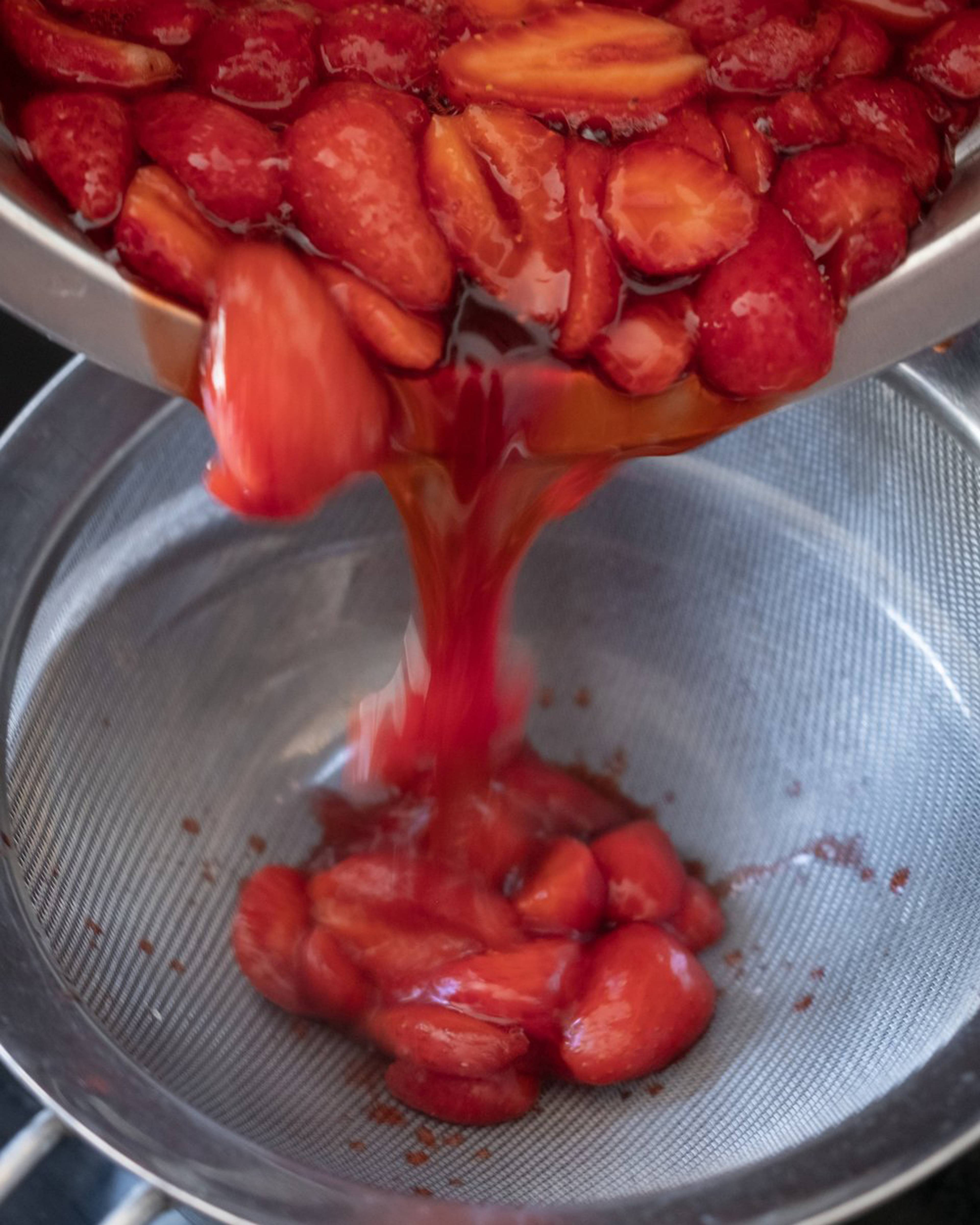 Simmered strawberries being strained