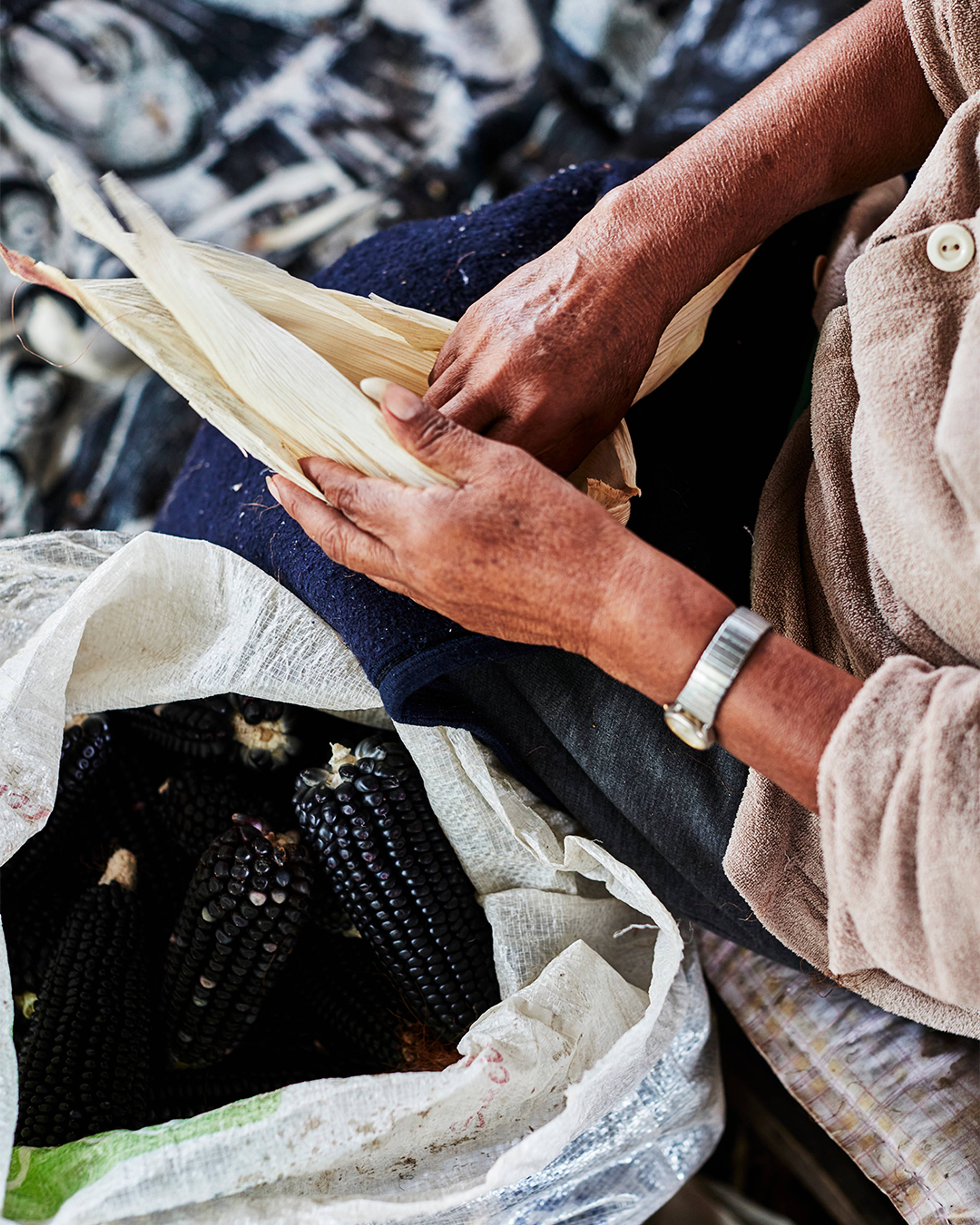 Woman shucking corn in Mexico