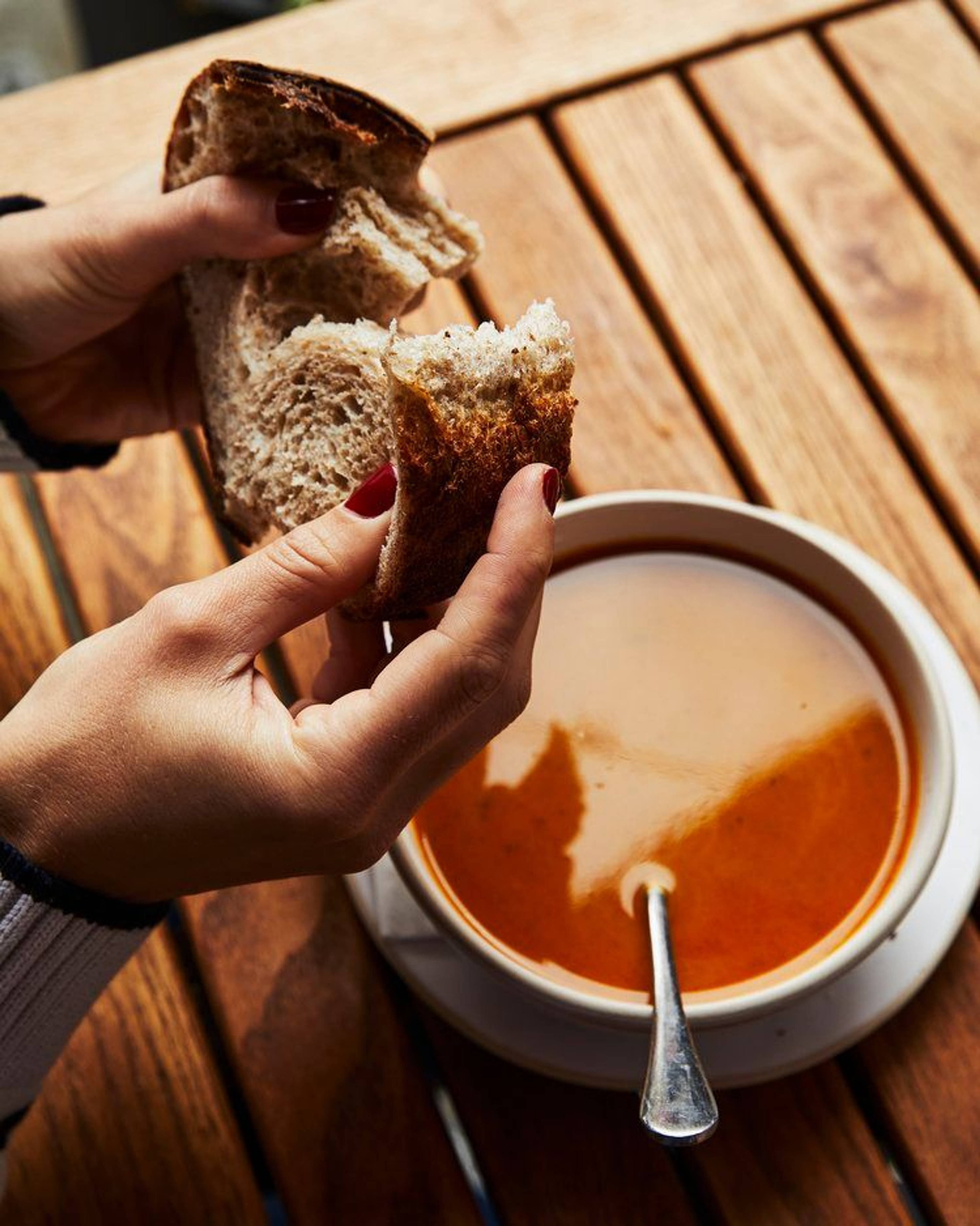 Tearing bread over delica soup