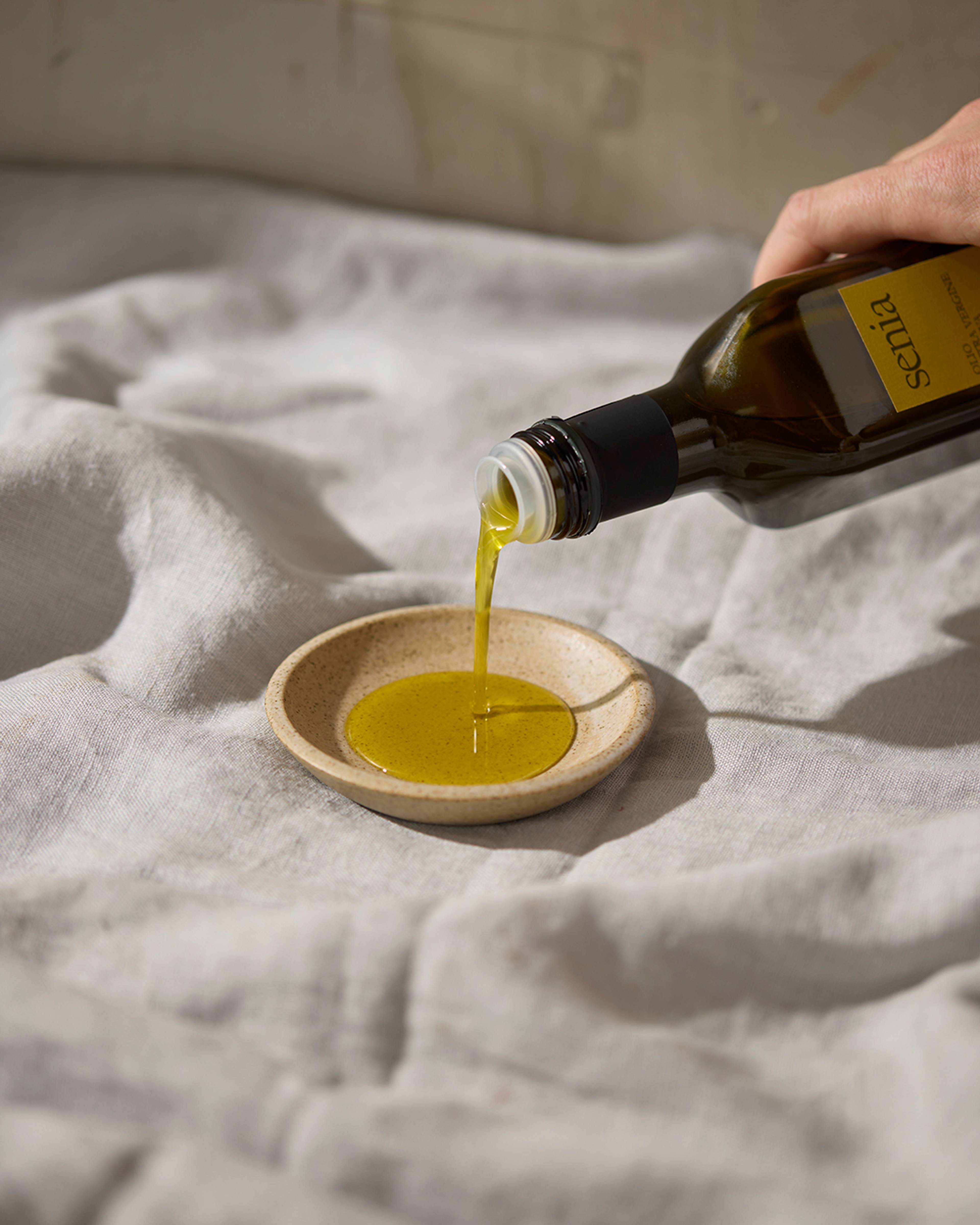 senia olive oil being poured onto a small plate