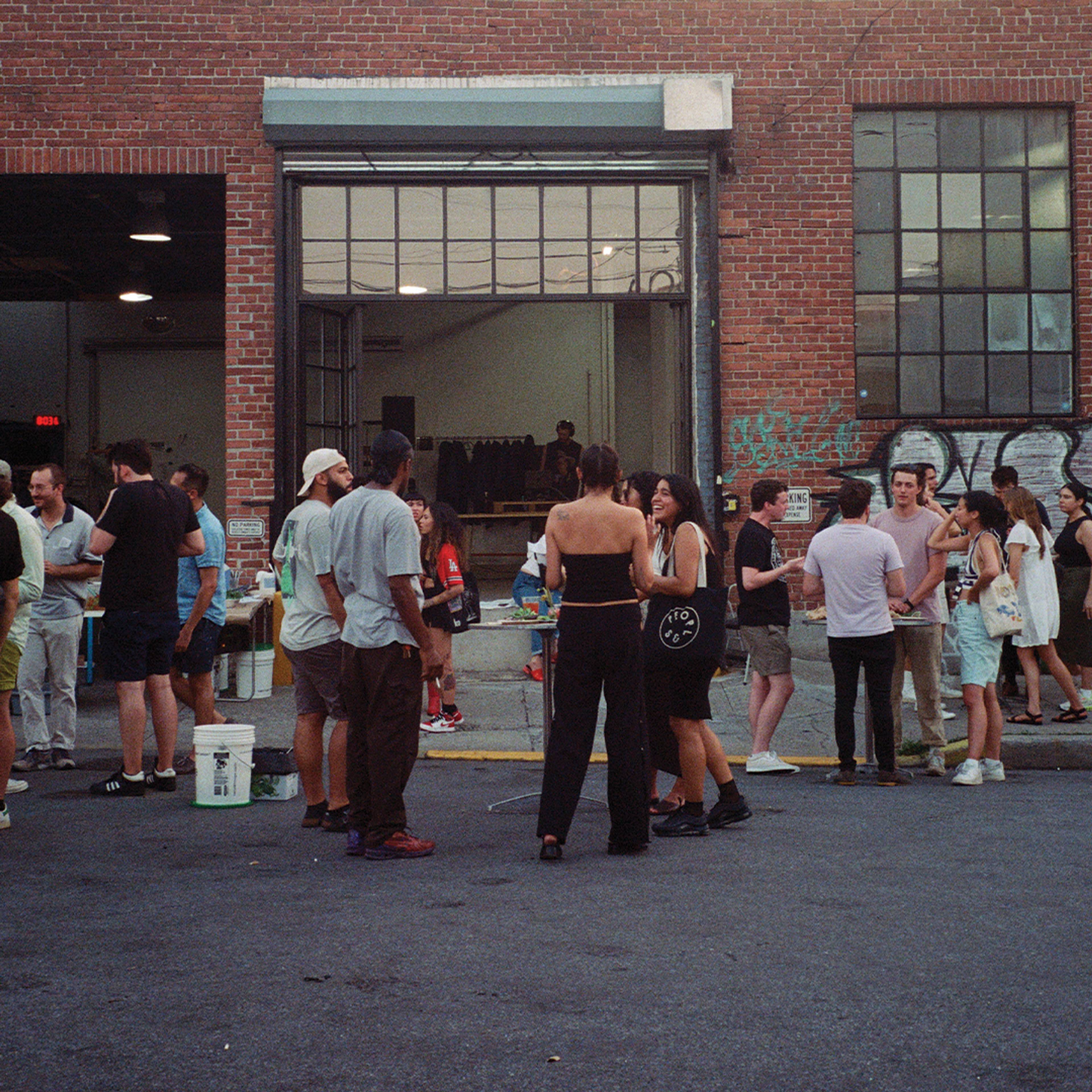 people standing outside of natoora warehouse