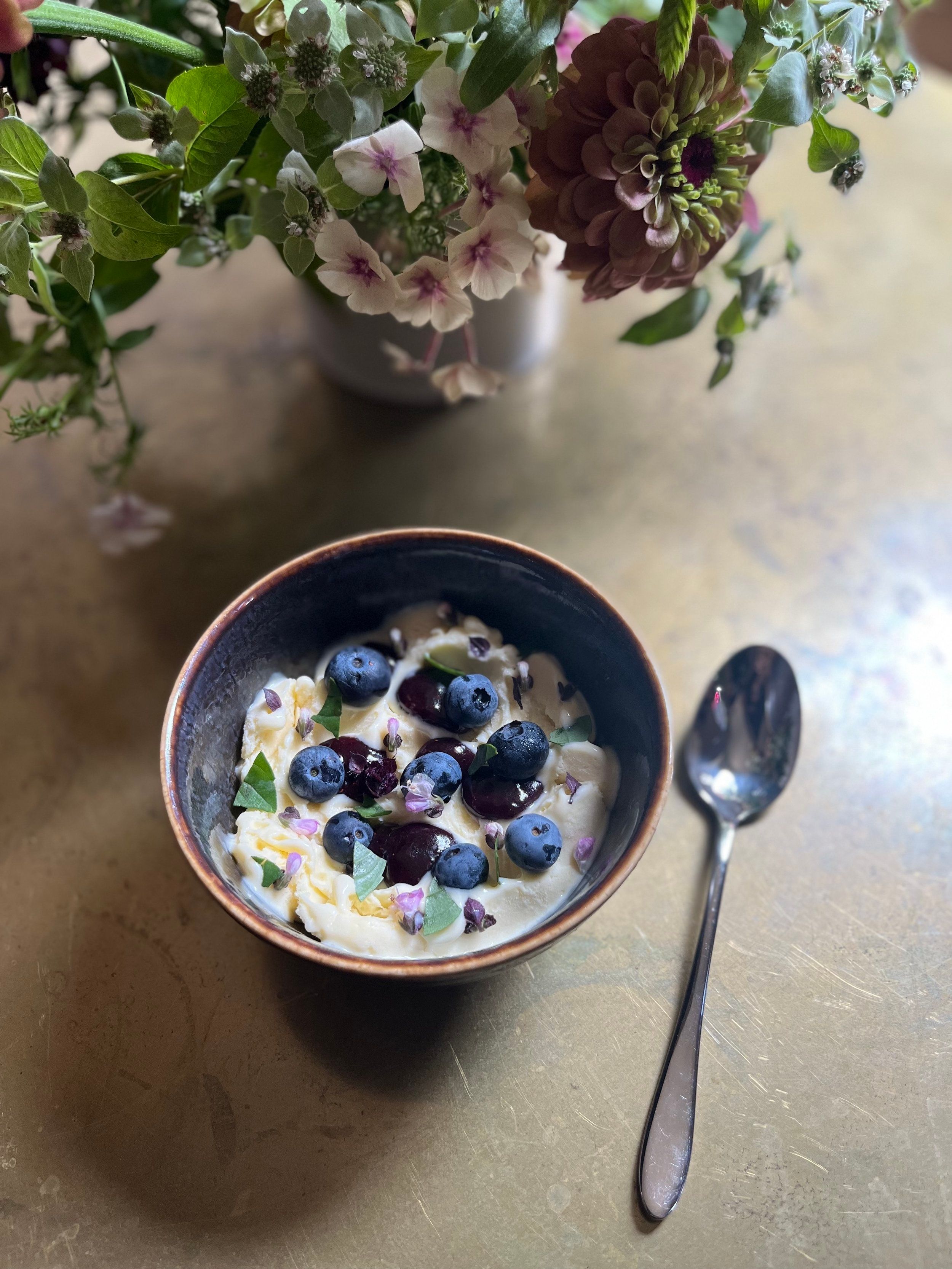 Blueberry jam in a bowl with ice cream and fresh blueberries