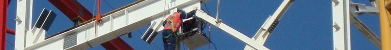 Trabajador con arnés en altura sobre una estructura metálica