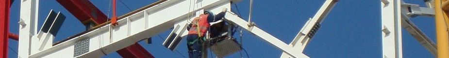 Trabajador con arnés en altura sobre una estructura metálica