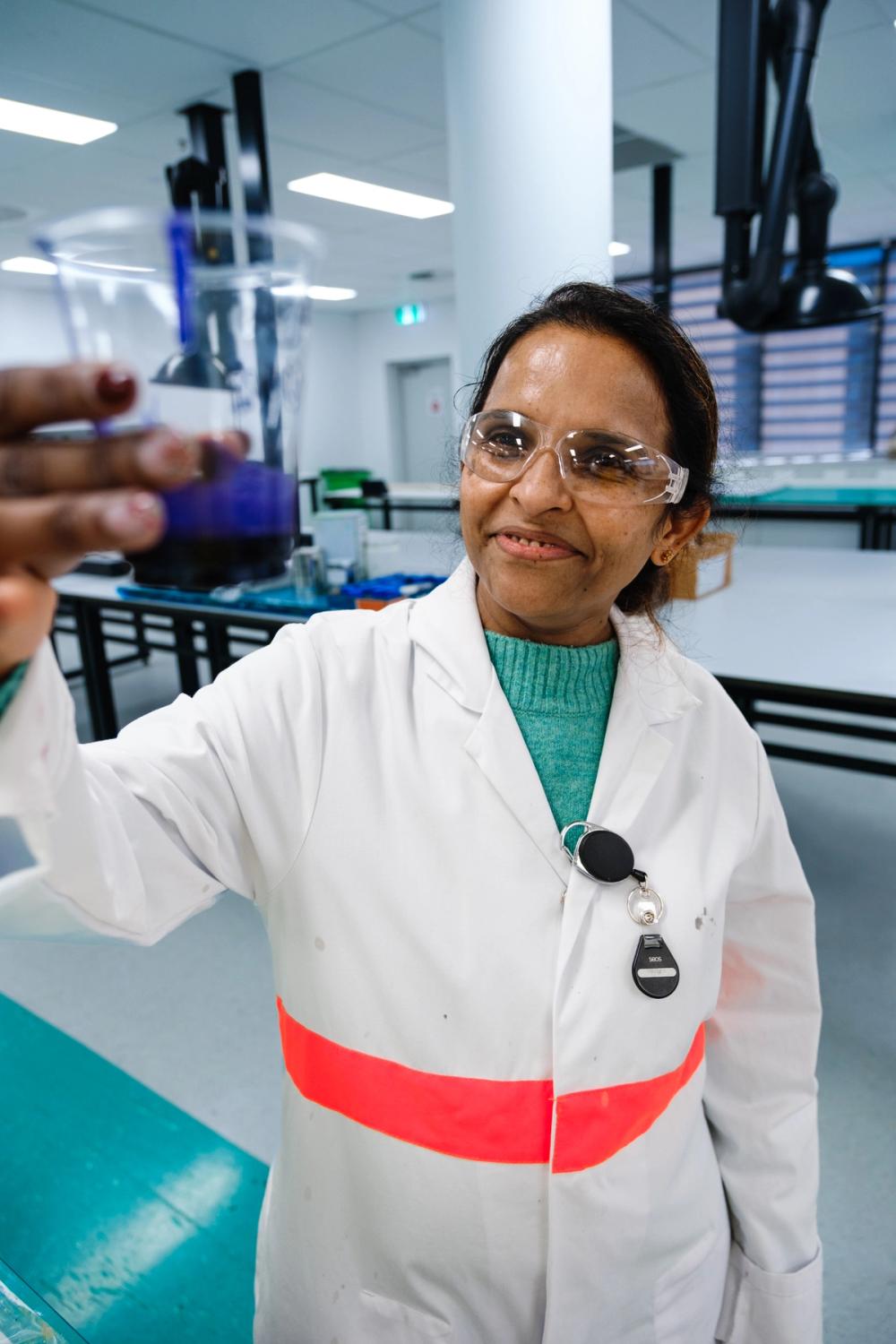 a woman in a lab coat is holding a glass a woman in a lab coat is holding a glass