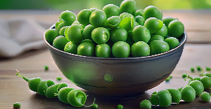 A bowl of fresh green peas on a wooden table with a sprinkle of sea salt and soft-focus greenery in the background.