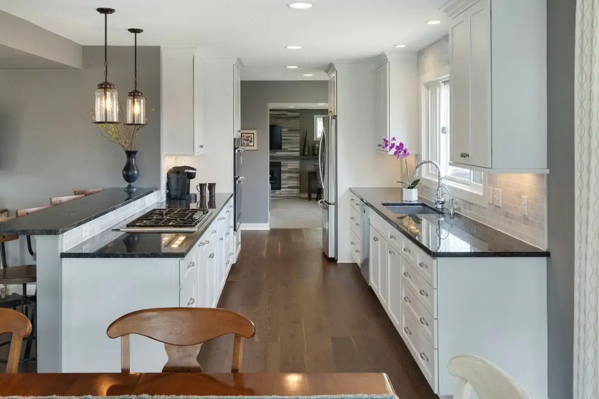 Galley kitchen with two parallel counters and dark granite worktops
