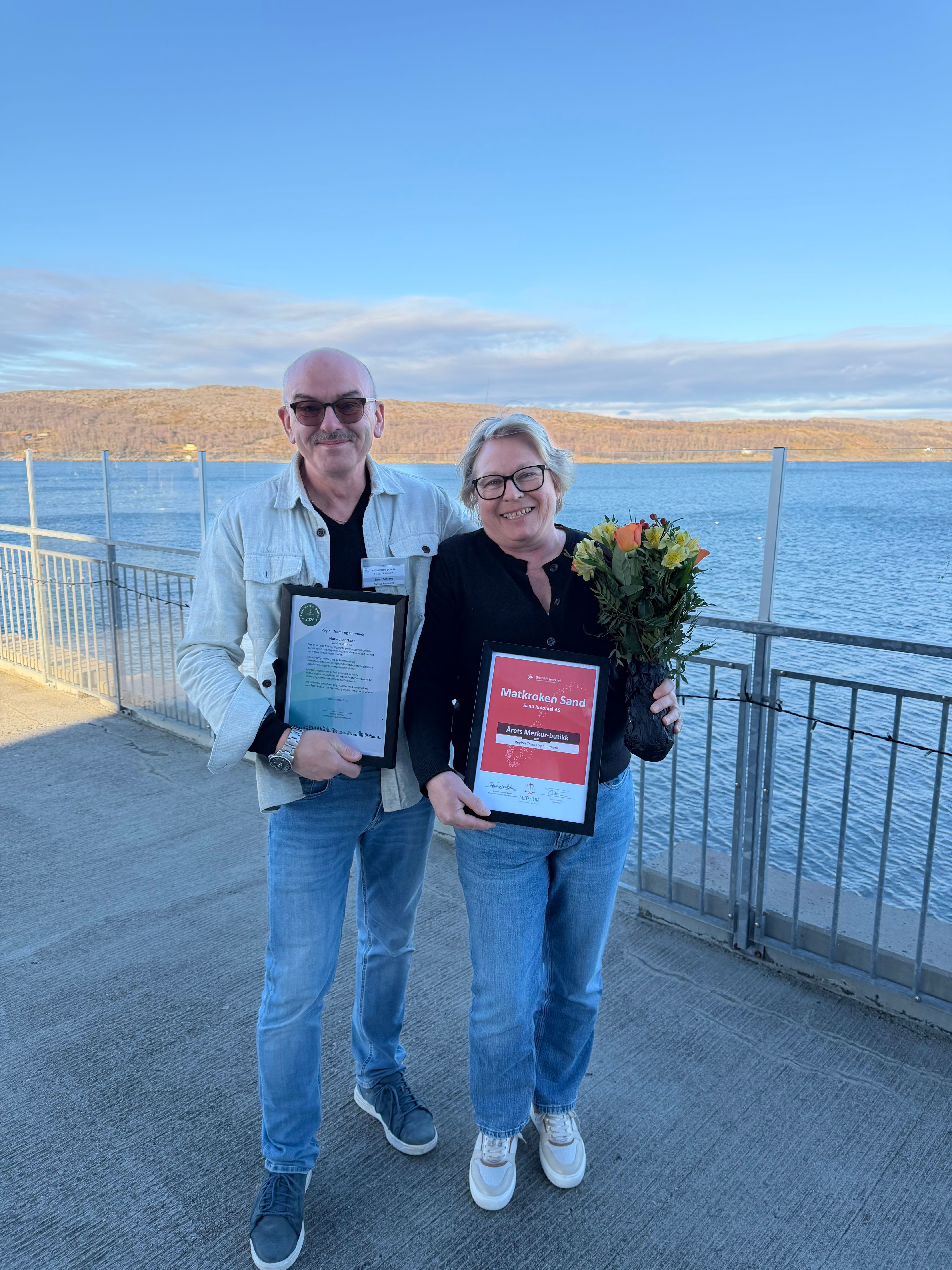 Folk med blomster og diplom