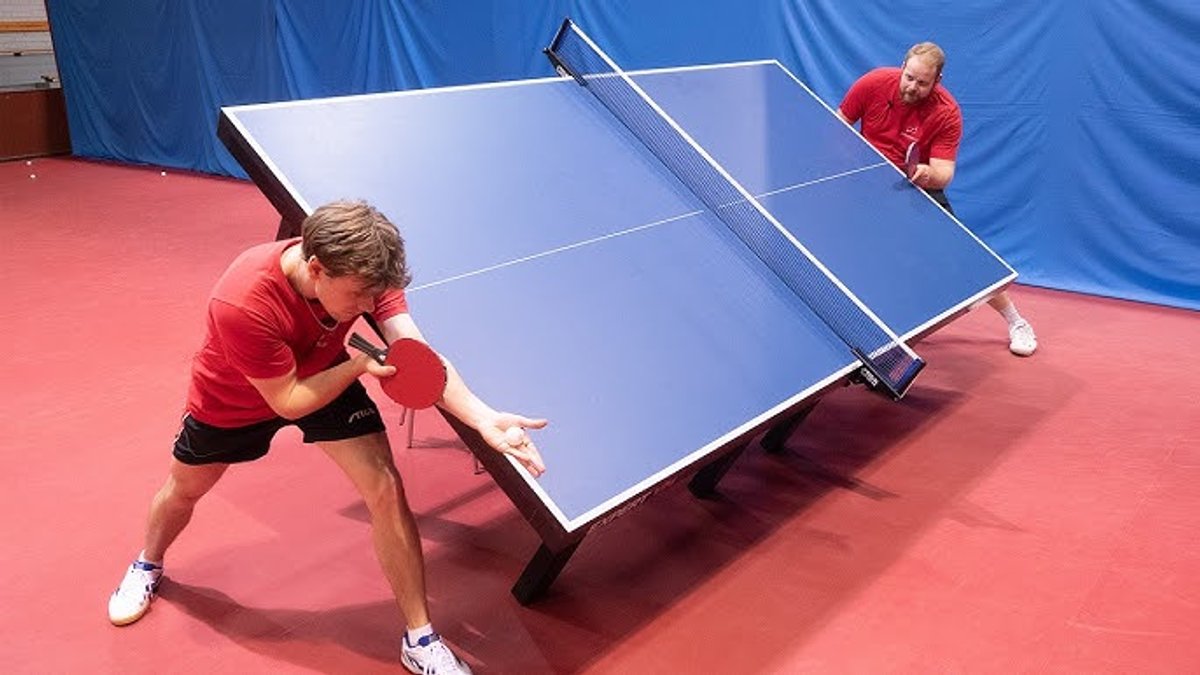Image of ping pong with a table at 45 degrees and players at either side.