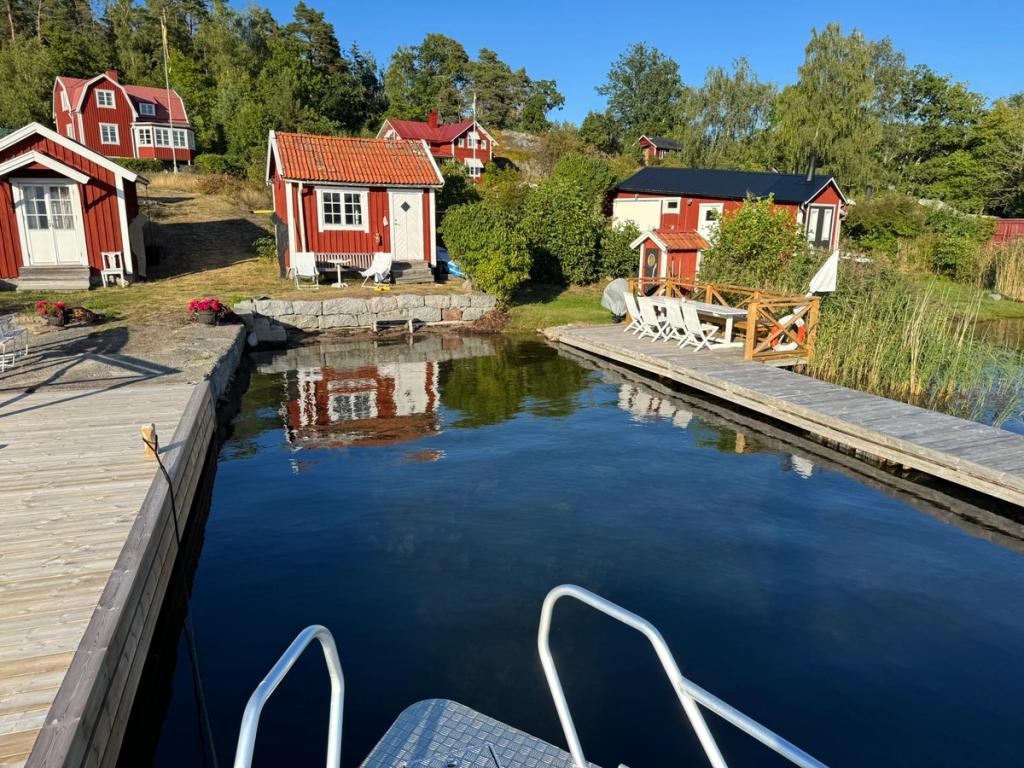Röda stugor och bryggor på Ingmarsö i kvällssol, kursens övernattning.