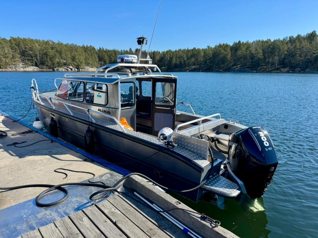 Flanör vid bryggan, sedd bakifrån med utombordsmotorn i förgrunden.