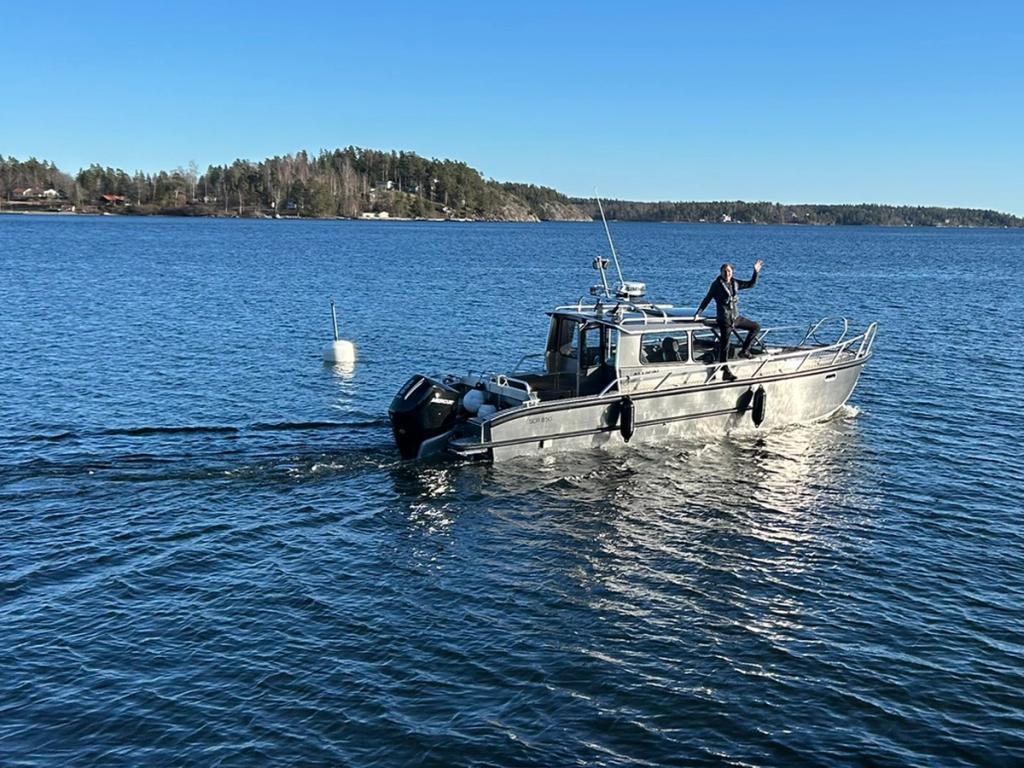 Niklas Forsén vinkar från Flanör ute på fjärden.
