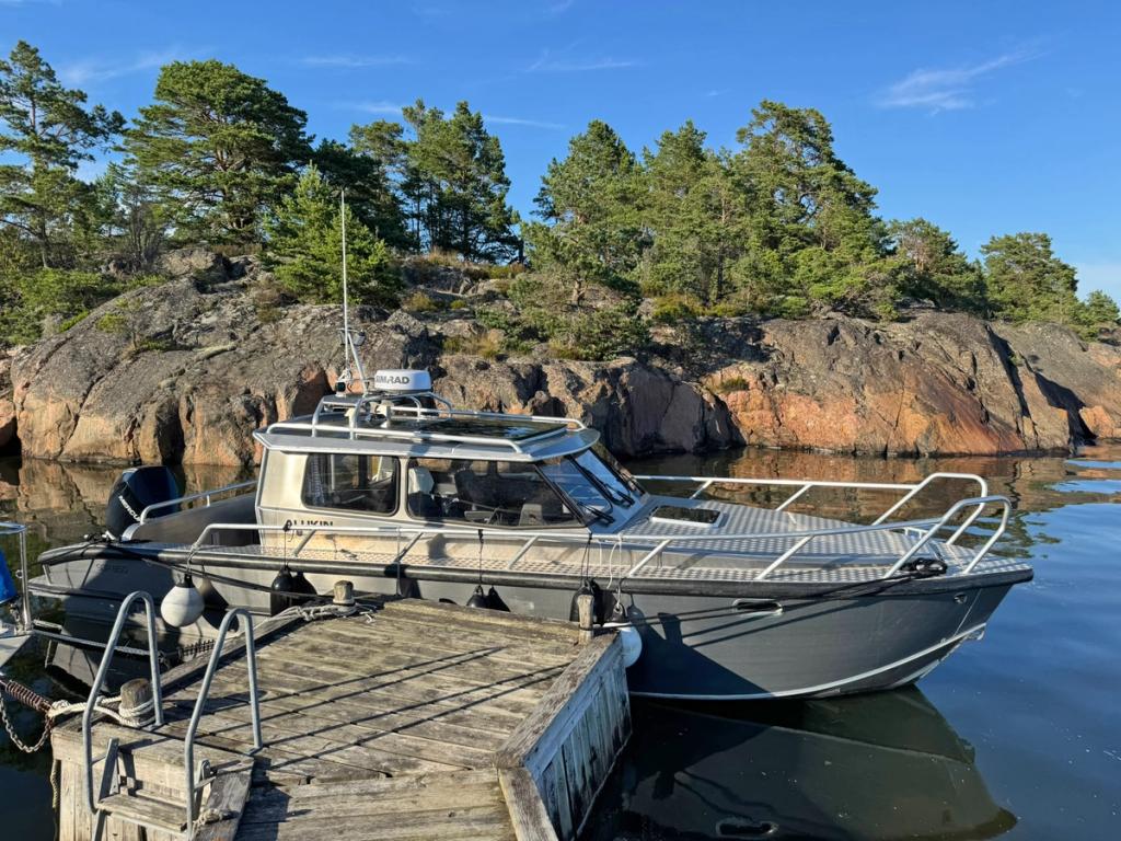 Flanör vid en brygga intill släta klippor i kvällssol.