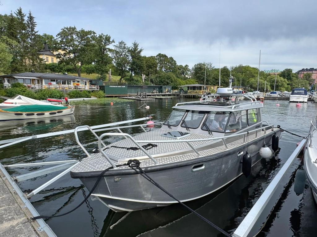 Flanör förtöjd vid bryggan i Stockholm med kursdeltagare i styrhytten.