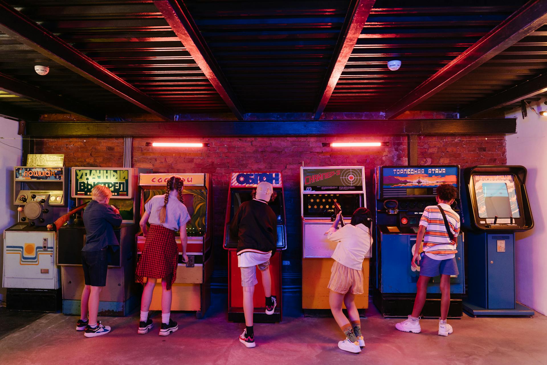 People Standing in Front of arcade games during Night Time