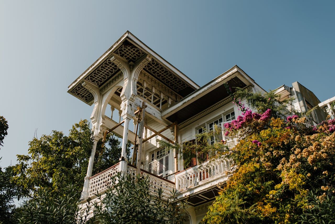 A photo of a white home with a balcony covered in plants