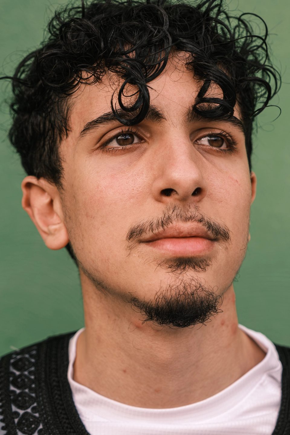 Close-up portrait of a young man with curly dark hair