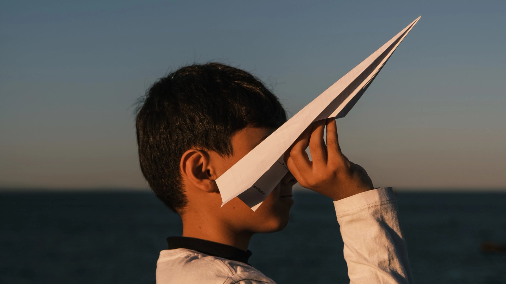 Child holding a paper airplane