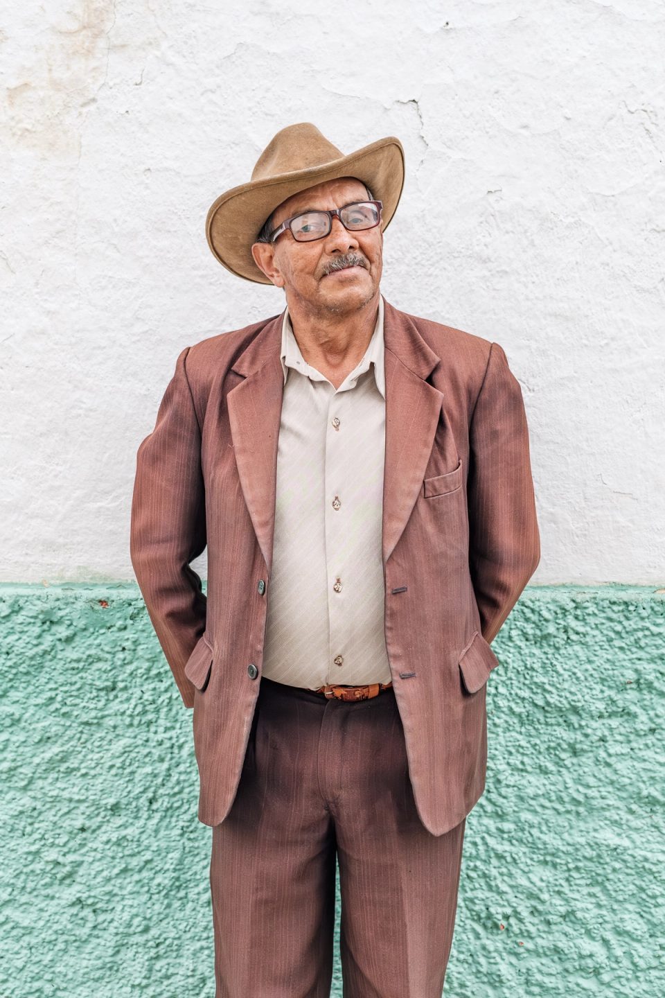 Older man wearing a brown suit and cowboy hat